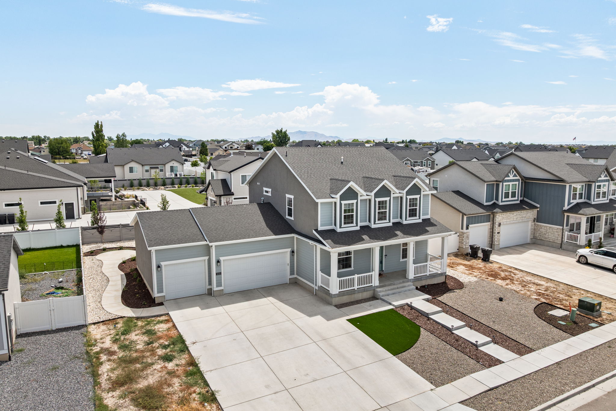 Contemporary two-story home featuring a three-car garage and a covered front porch