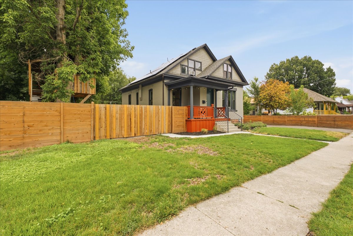 Craftsman-style home featuring a covered front porch with orange railings, a gray exterior, and a gabled roofline