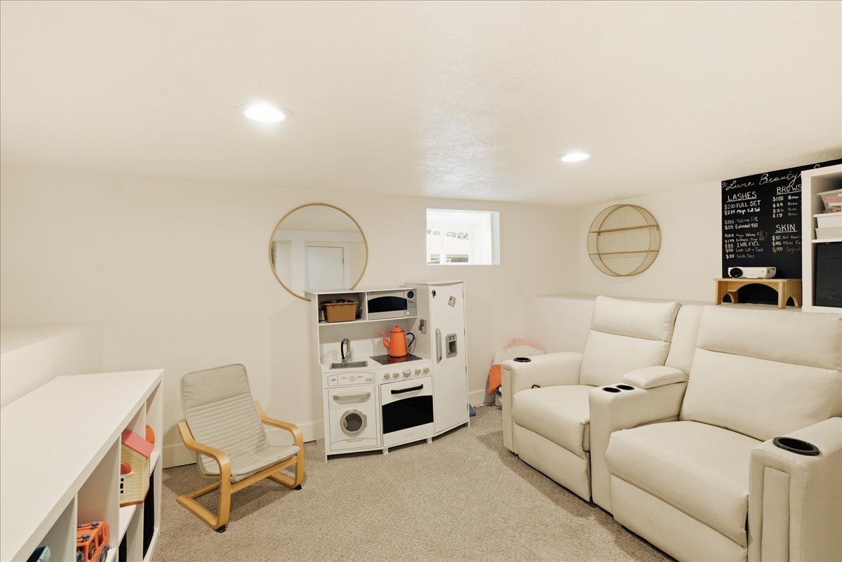 Carpeted recreational room with recessed lighting and a built-in shelving unit