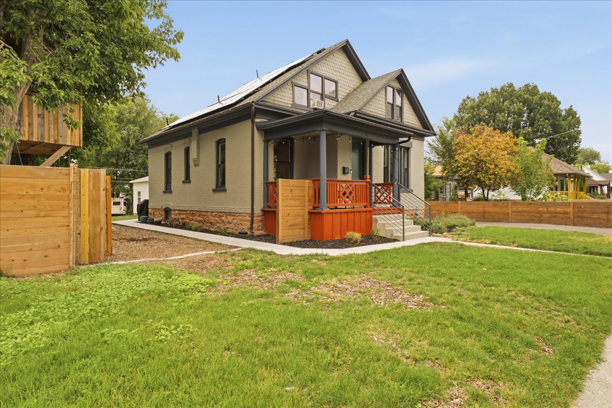 Exterior featuring a covered porch with decorative railing, brick foundation, and gabled roofline