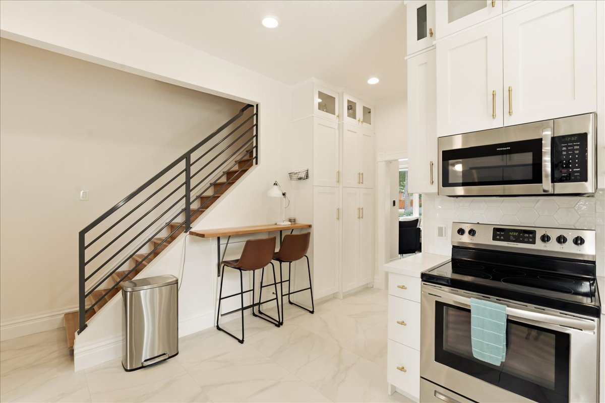 Bright kitchen with white cabinetry and stainless steel appliances