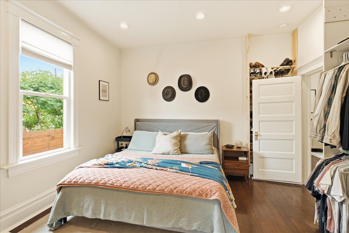 Bedroom featuring wood-finish flooring, recessed lighting, a window with exterior views, and a closet with built-in shelving