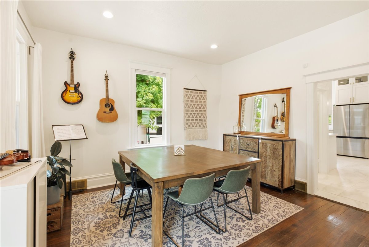Dining area featuring wood-finish flooring, recessed lighting, a window with natural light, and a wide entryway