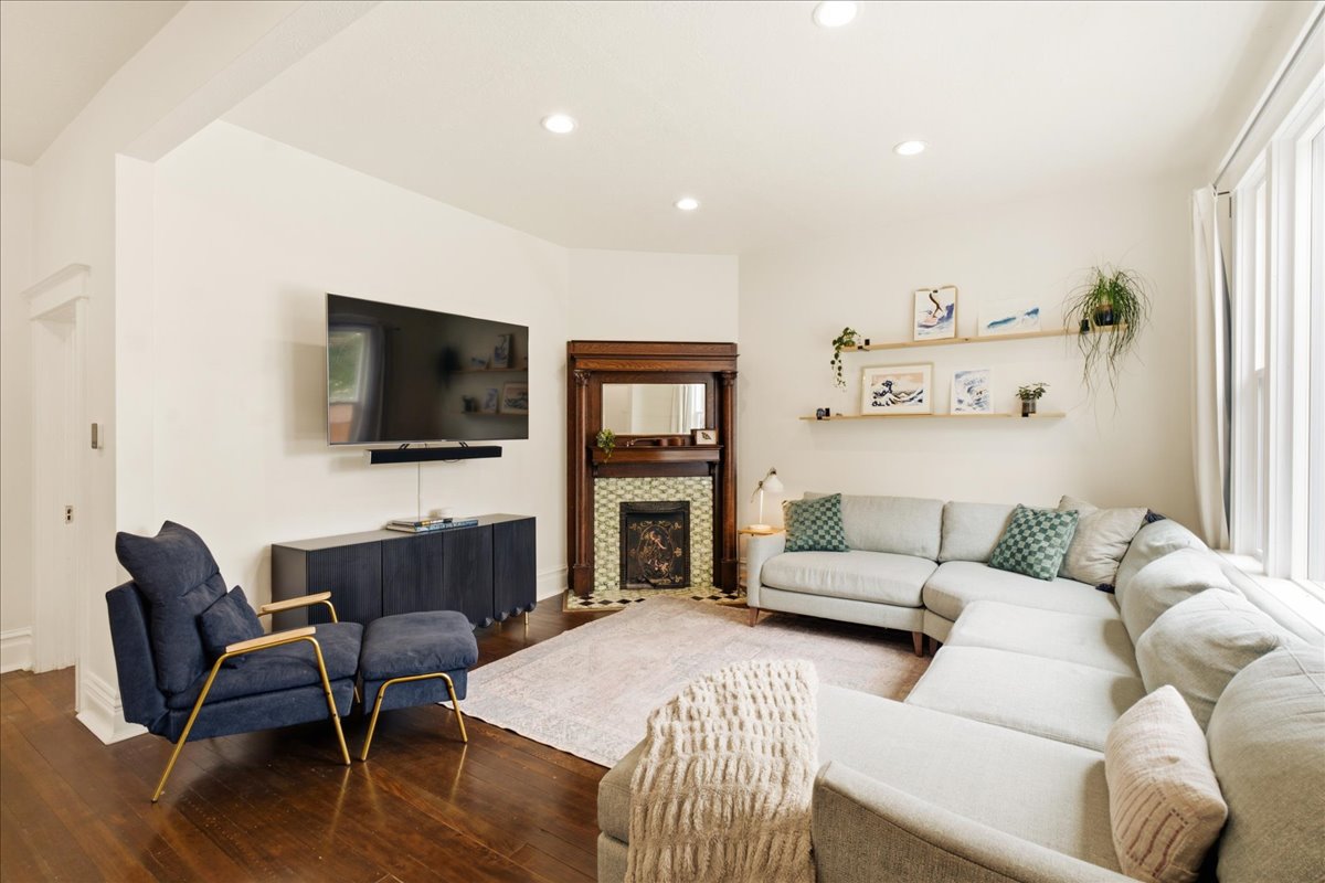 Living area featuring rich wood-finish flooring and recessed lighting