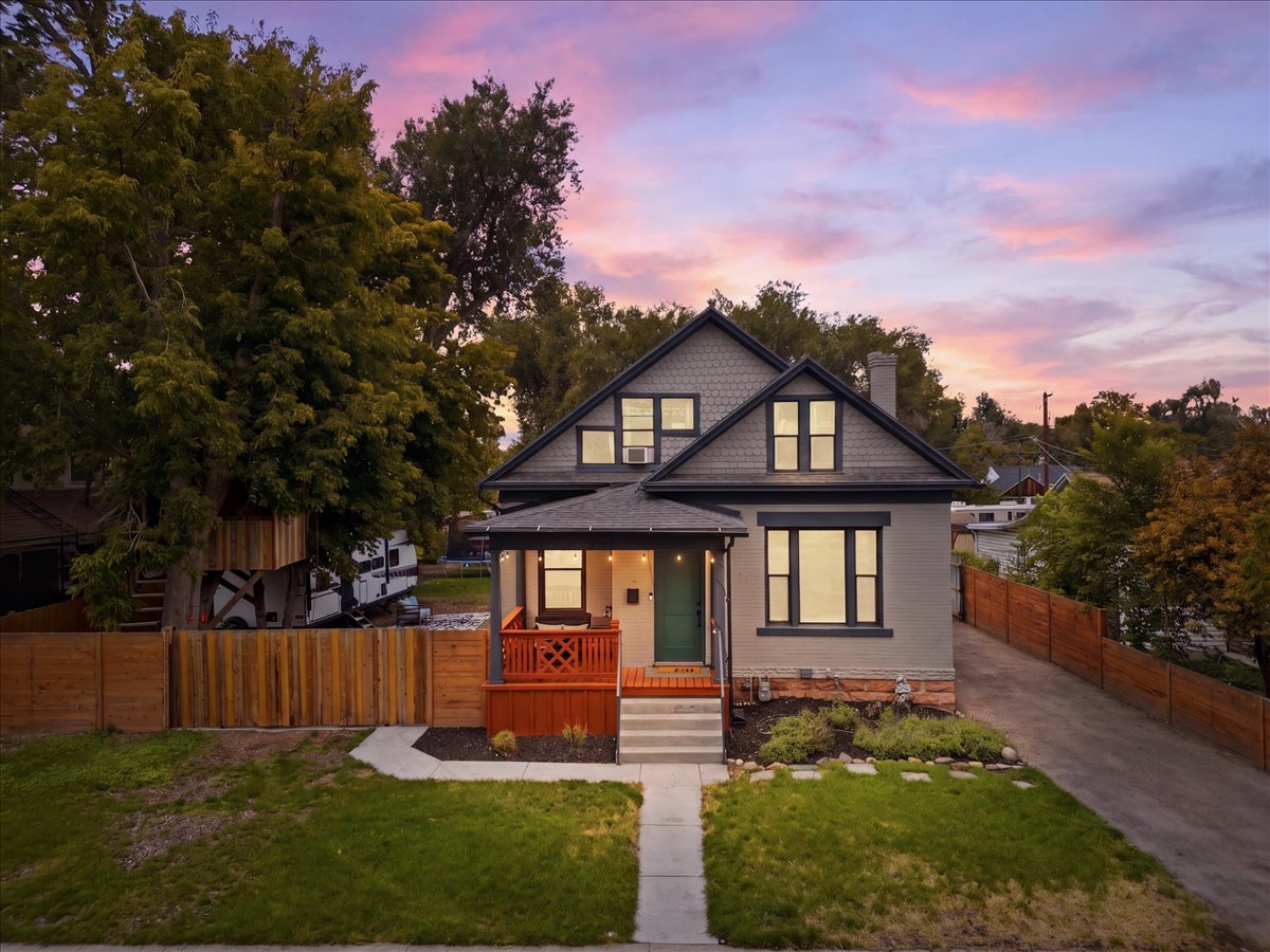 Renovated residence with an inviting covered porch and a vibrant green front lawn