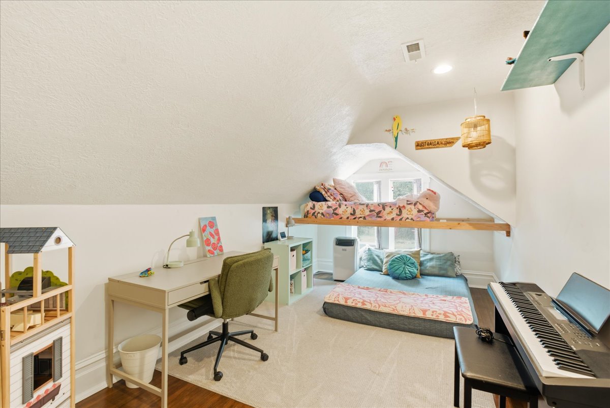 Attic room with sloped ceilings, a dormer window, recessed lighting, and a built-in elevated platform