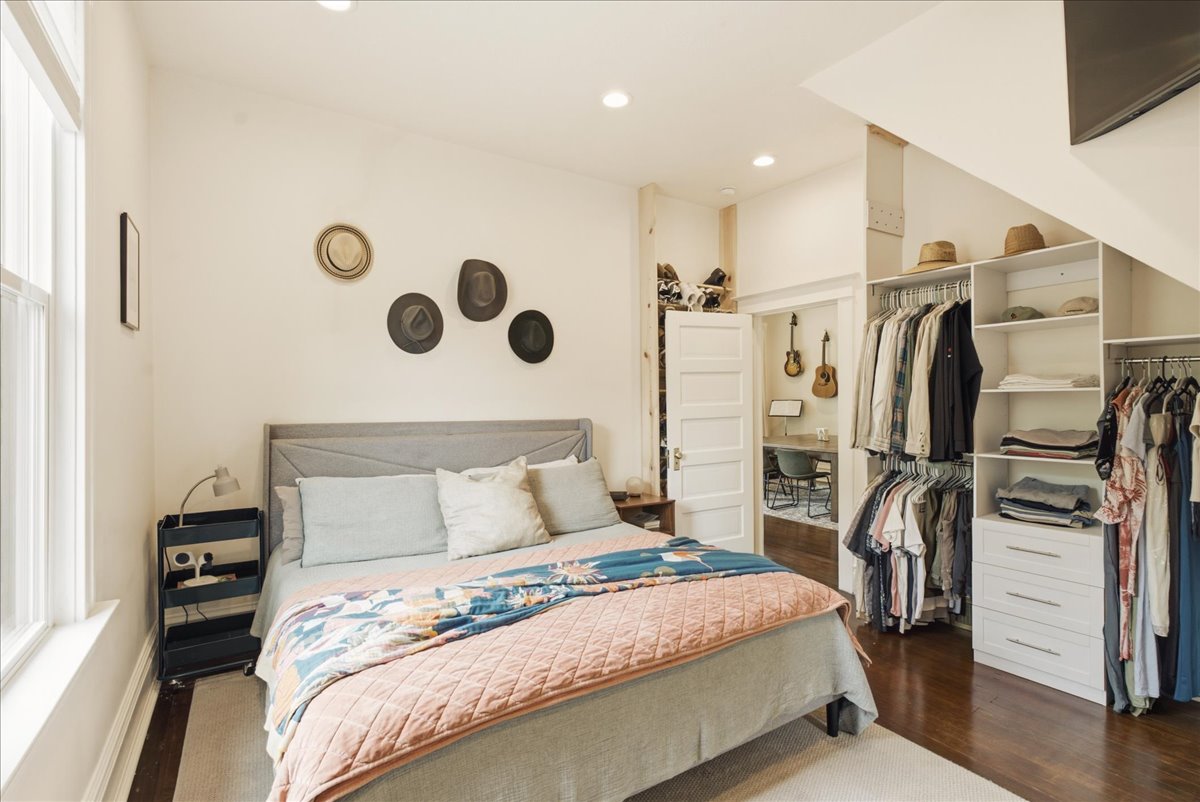 Bedroom featuring light-toned walls, recessed lighting, and dark wood-finish flooring