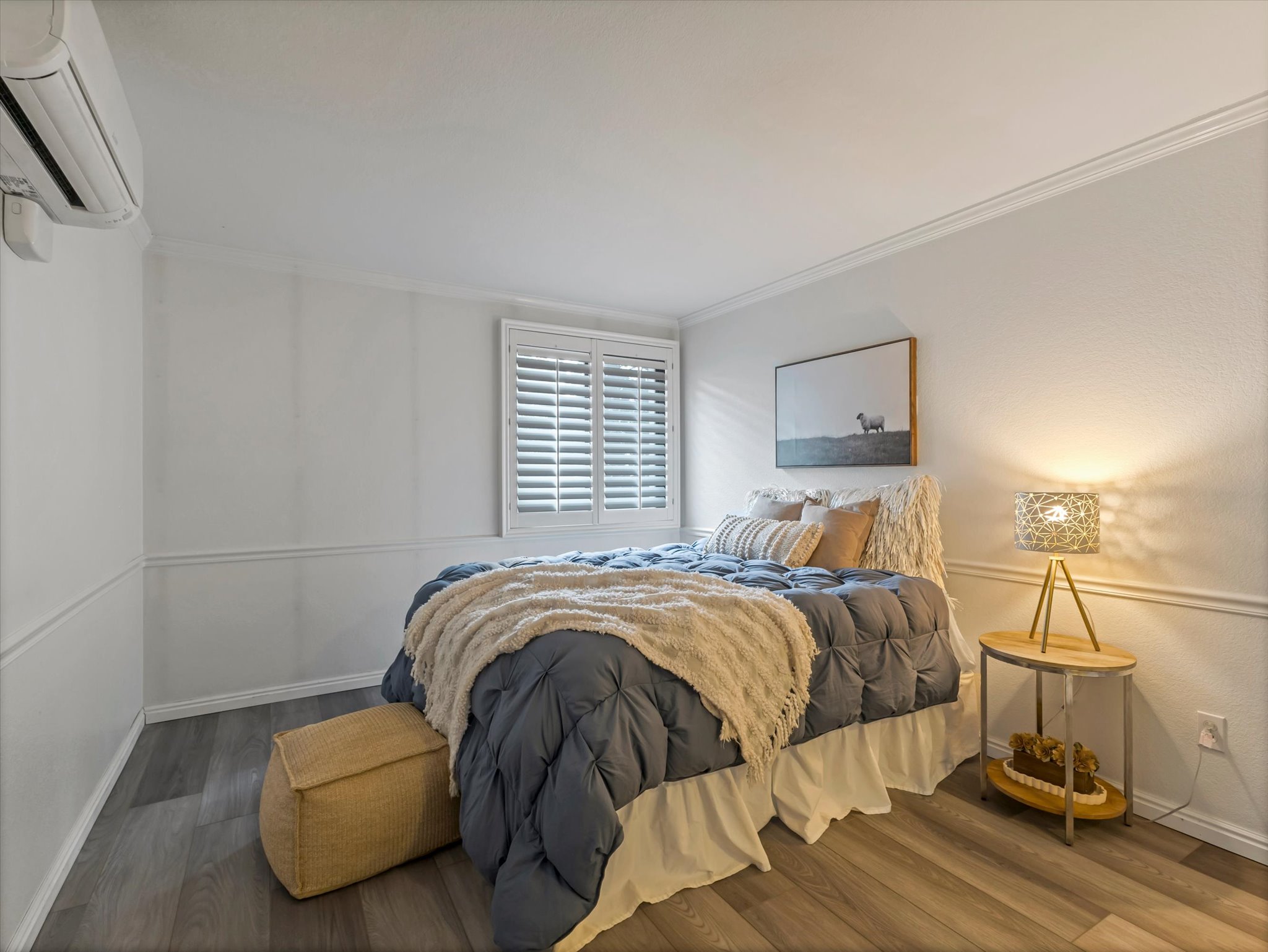 Interior room featuring wood-finish flooring, white wainscoting, and crown molding