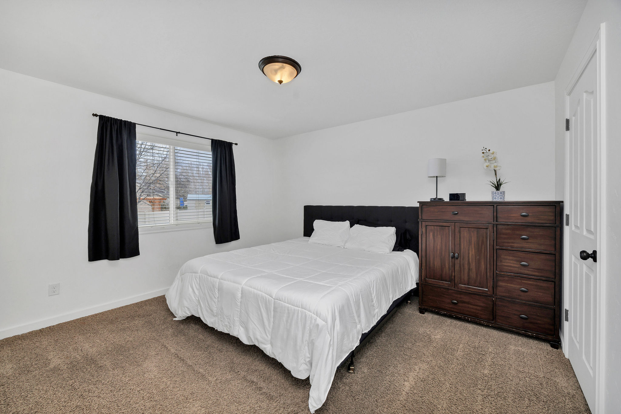 Bedroom featuring neutral tone carpeting and crisp white walls