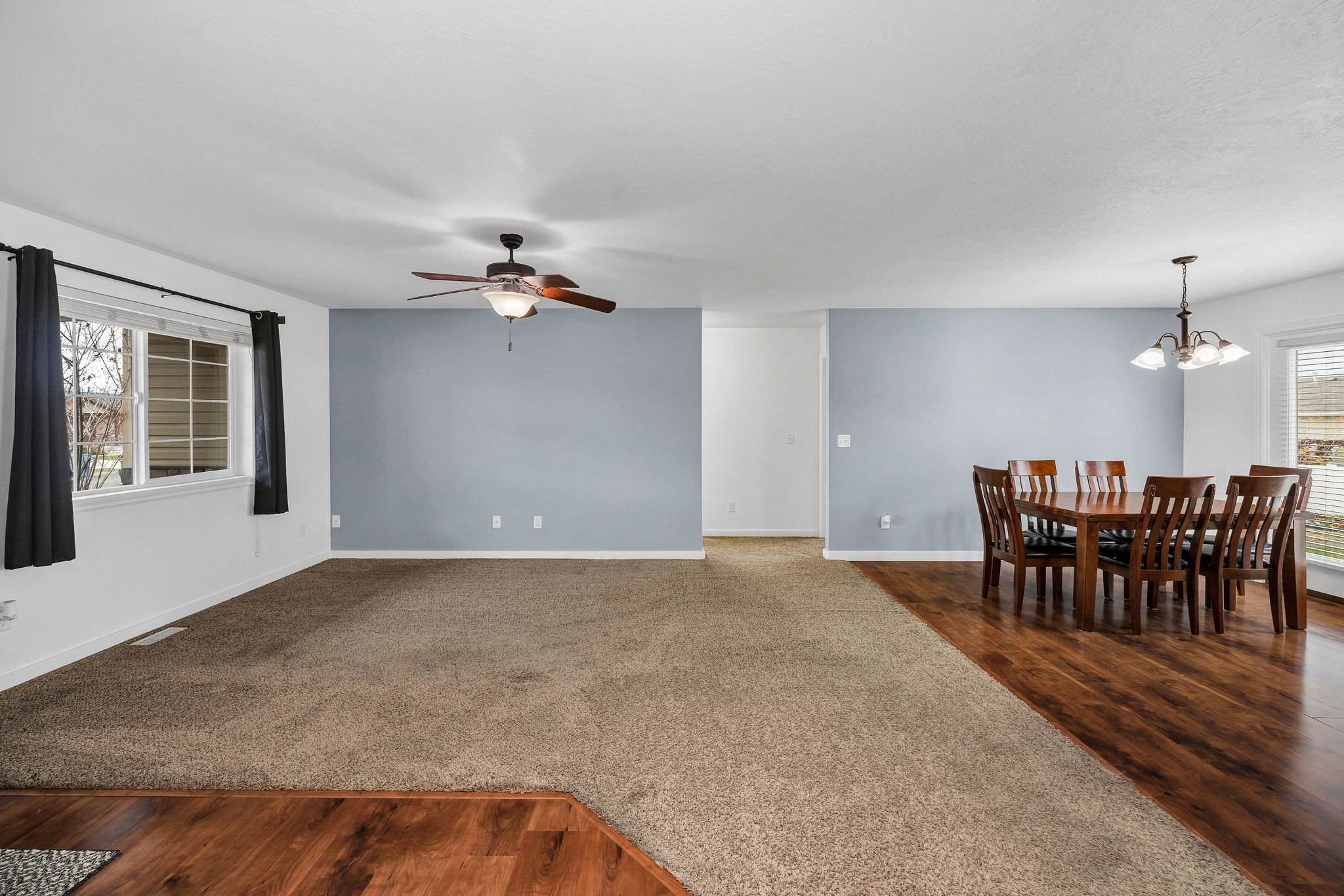 Spacious interior featuring a combination of wood-finish flooring and carpet