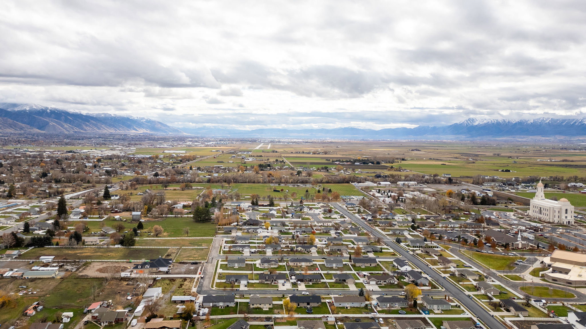Expansive aerial perspective showcasing a residential neighborhood with distant mountains