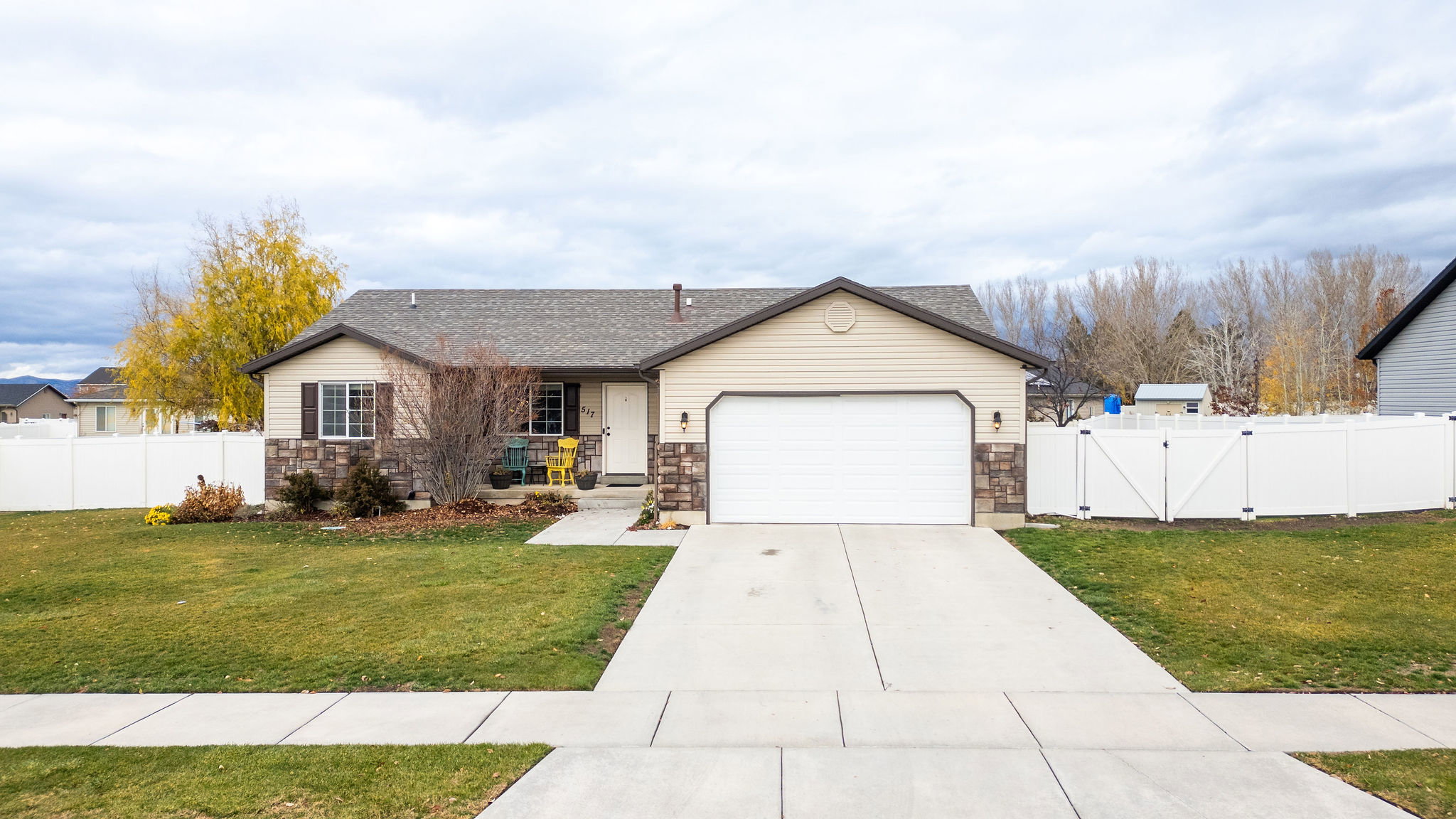 Ranch-style residence featuring a two-tone exterior with tan siding and stone veneer accents