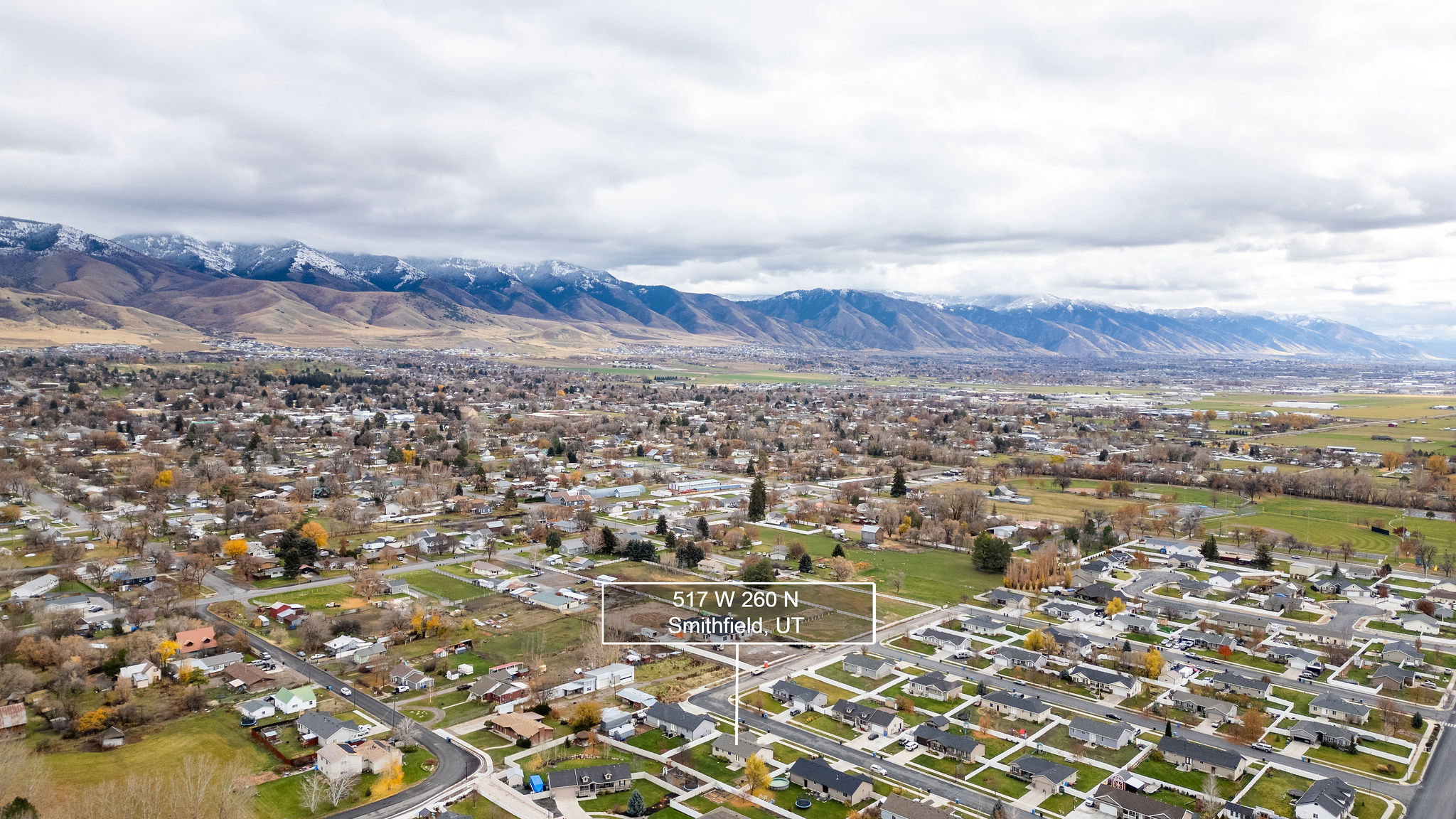 Expansive aerial showing a residential area with a prominent mountain range backdrop