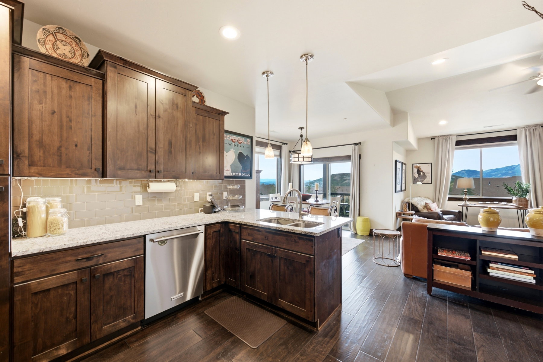 Kitchen featuring wood-finish cabinetry, light-toned countertops, and a stainless steel dishwasher