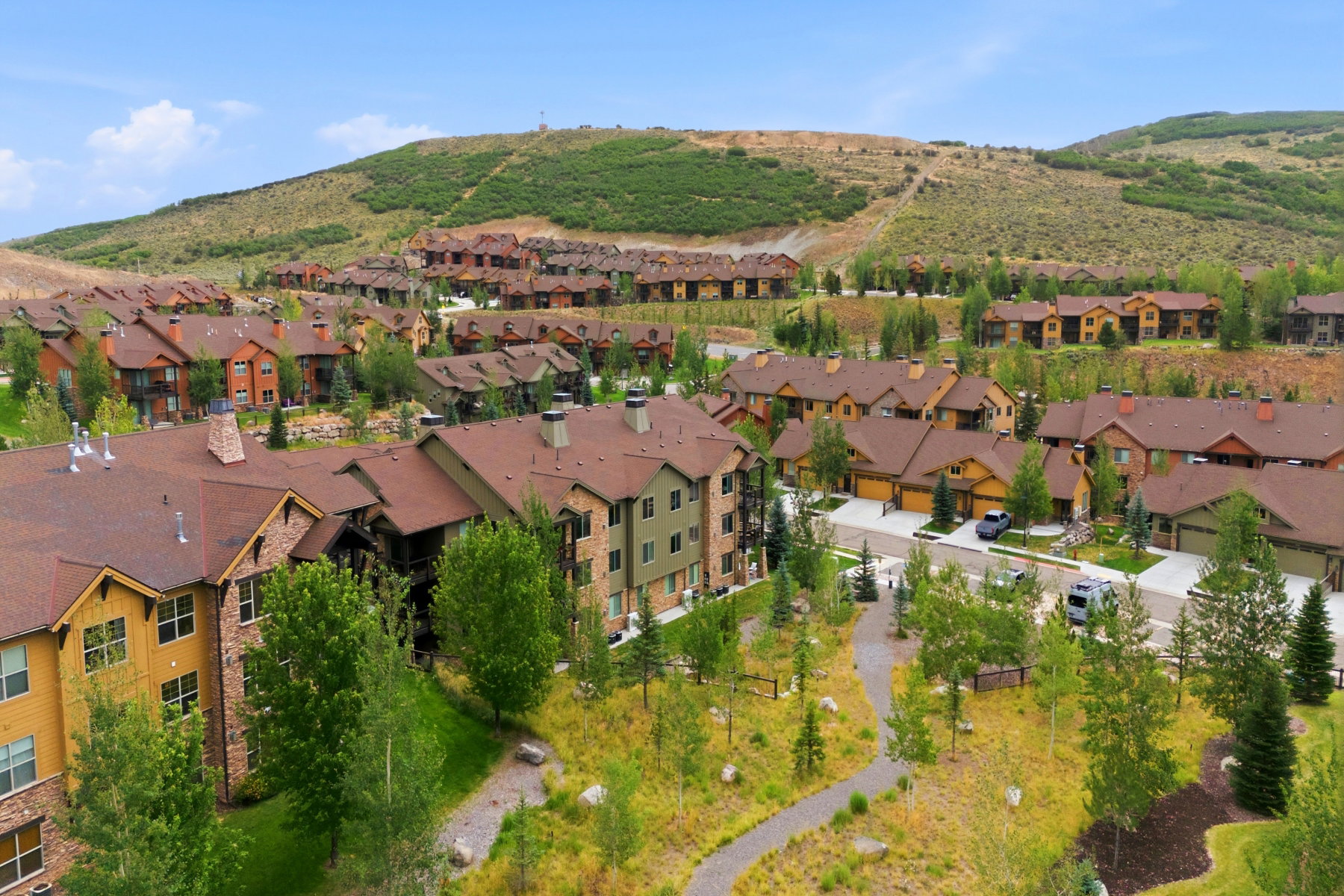 Residential community with multi-level dwellings, pitched roofs, and varied exterior finishes