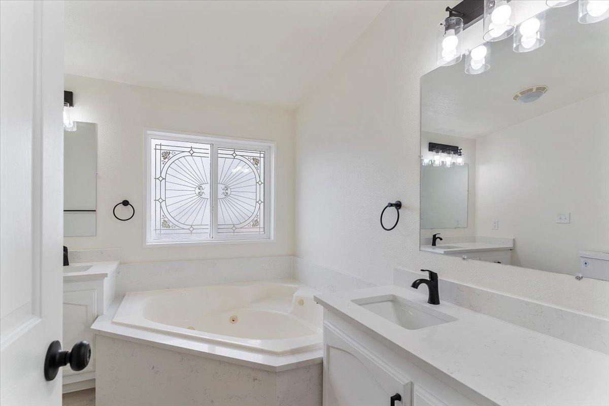 Corner soaking tub with a decorative privacy window