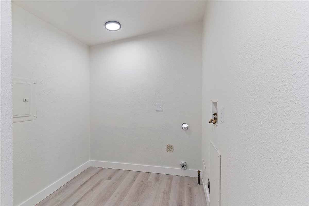 Utility space featuring light wood-finish flooring, white walls, and a recessed ceiling light fixture