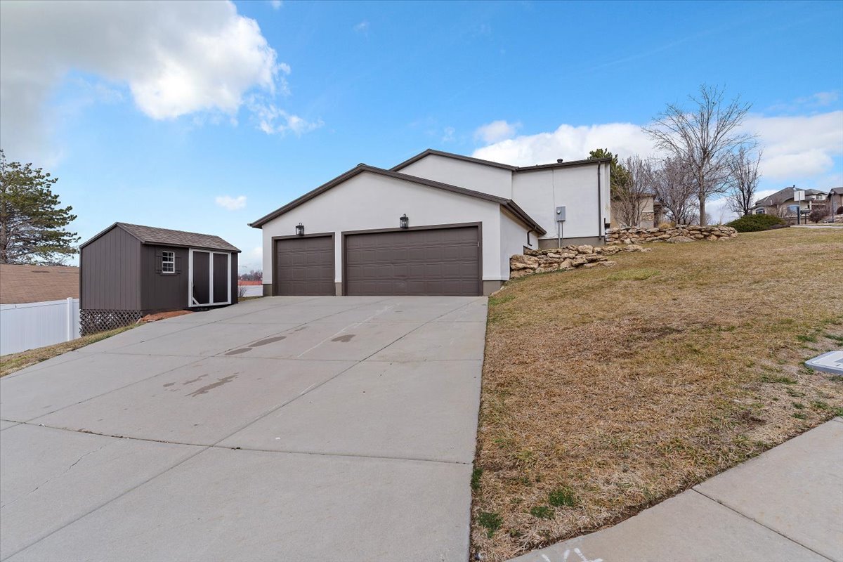 Two-car garage with individual doors, exterior lighting fixtures, and a concrete driveway