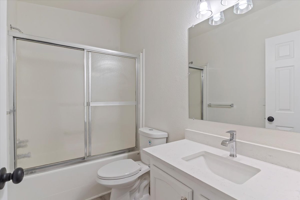 Contemporary vanity featuring an integrated sink, polished chrome faucet, and expansive wall-mounted mirror
