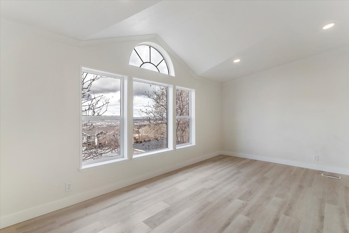Vaulted ceiling room featuring a large arched transom window above three rectangular windows