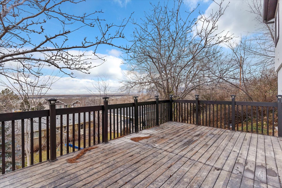 Expansive wood deck with dark-stained railing featuring post cap lighting