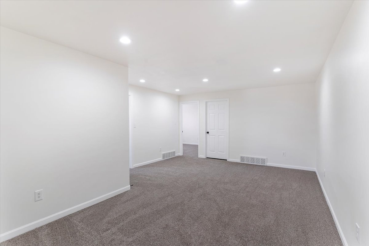 Spacious room featuring neutral carpeting and white walls