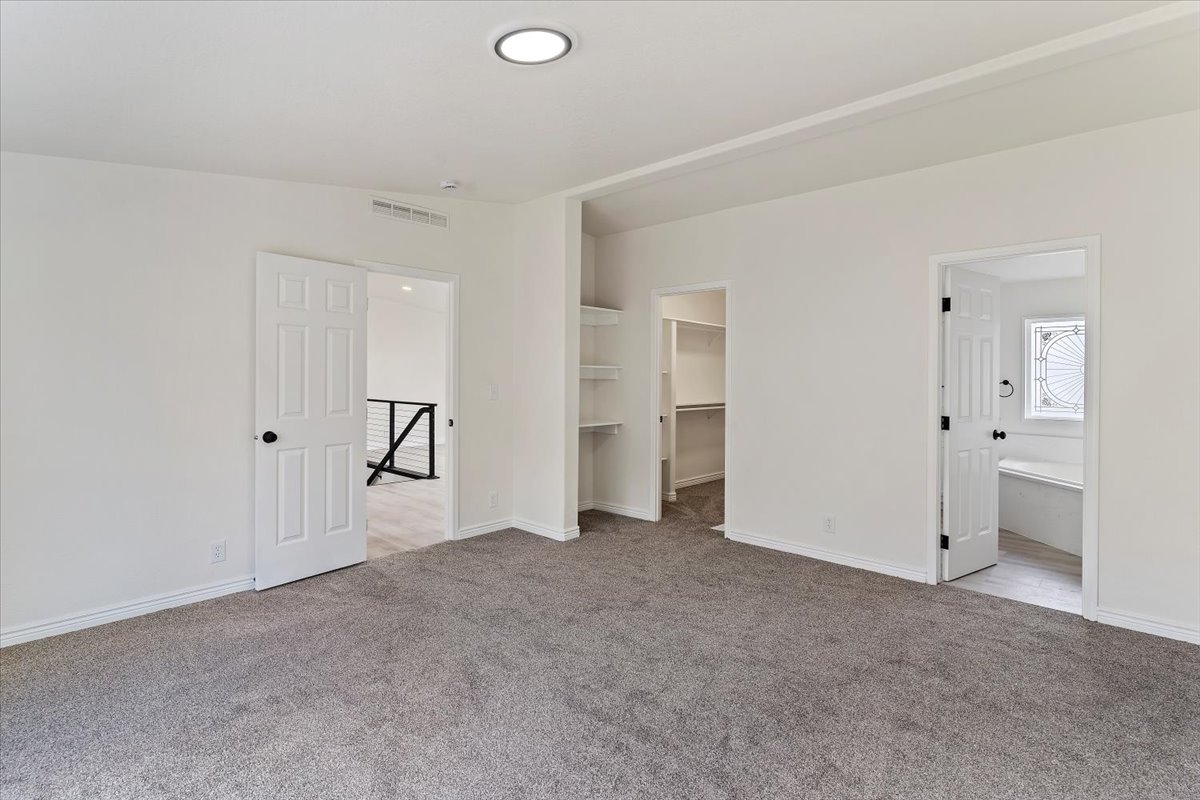 Carpeted room with recessed lighting, multiple doorways, and built-in shelving