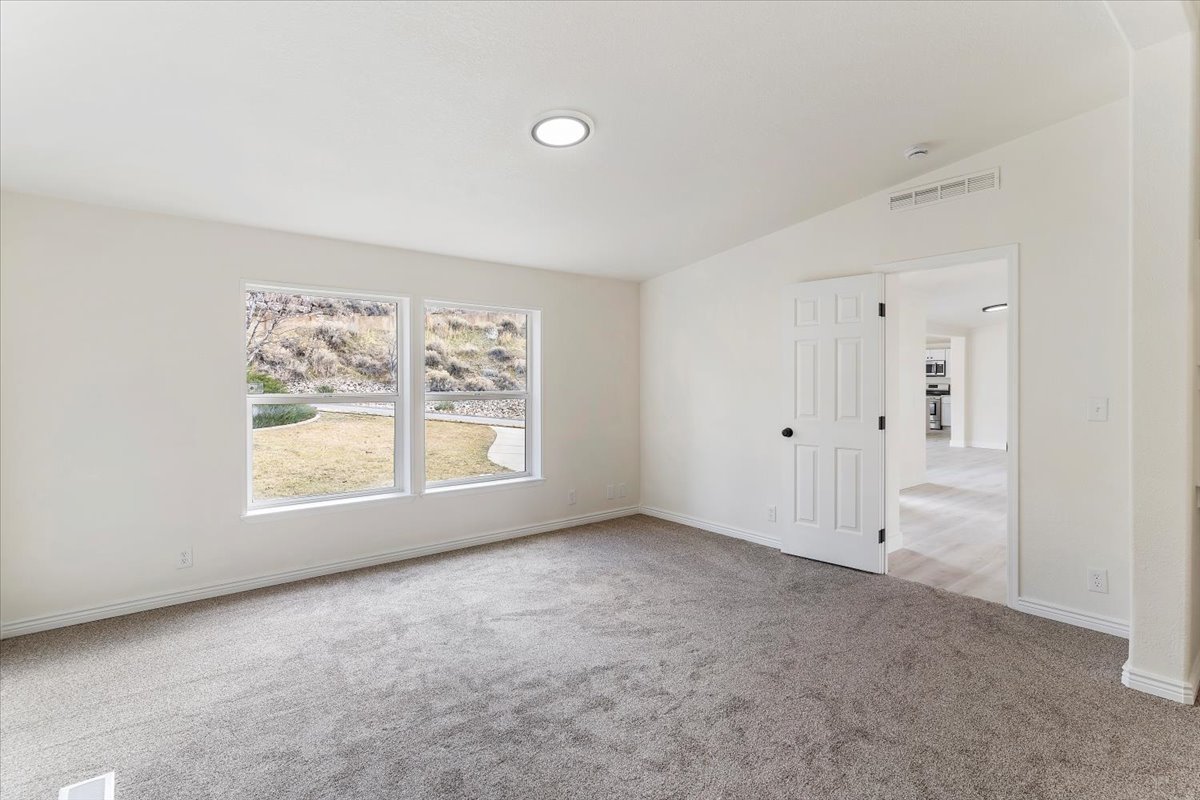 Interior room featuring two large windows, recessed ceiling lighting, and gray carpet flooring