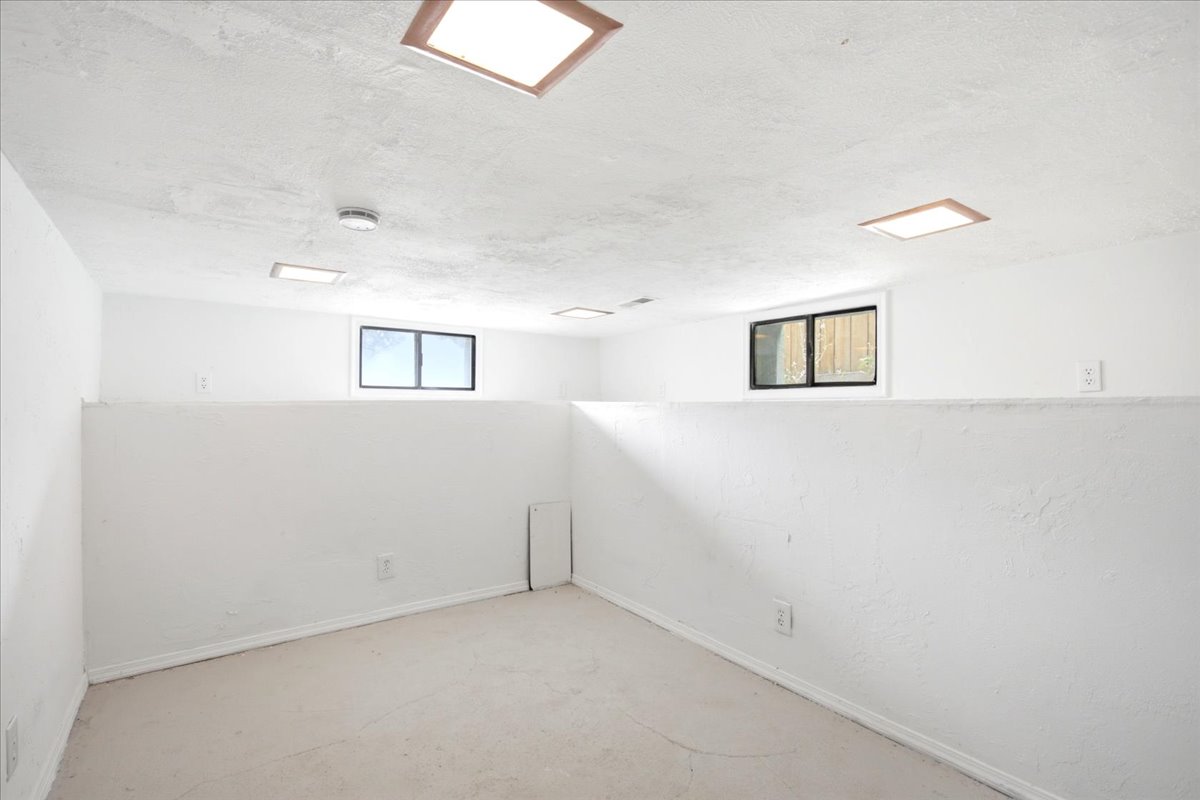 Brightly lit room featuring three recessed rectangular light fixtures and two horizontal windows providing natural illumination