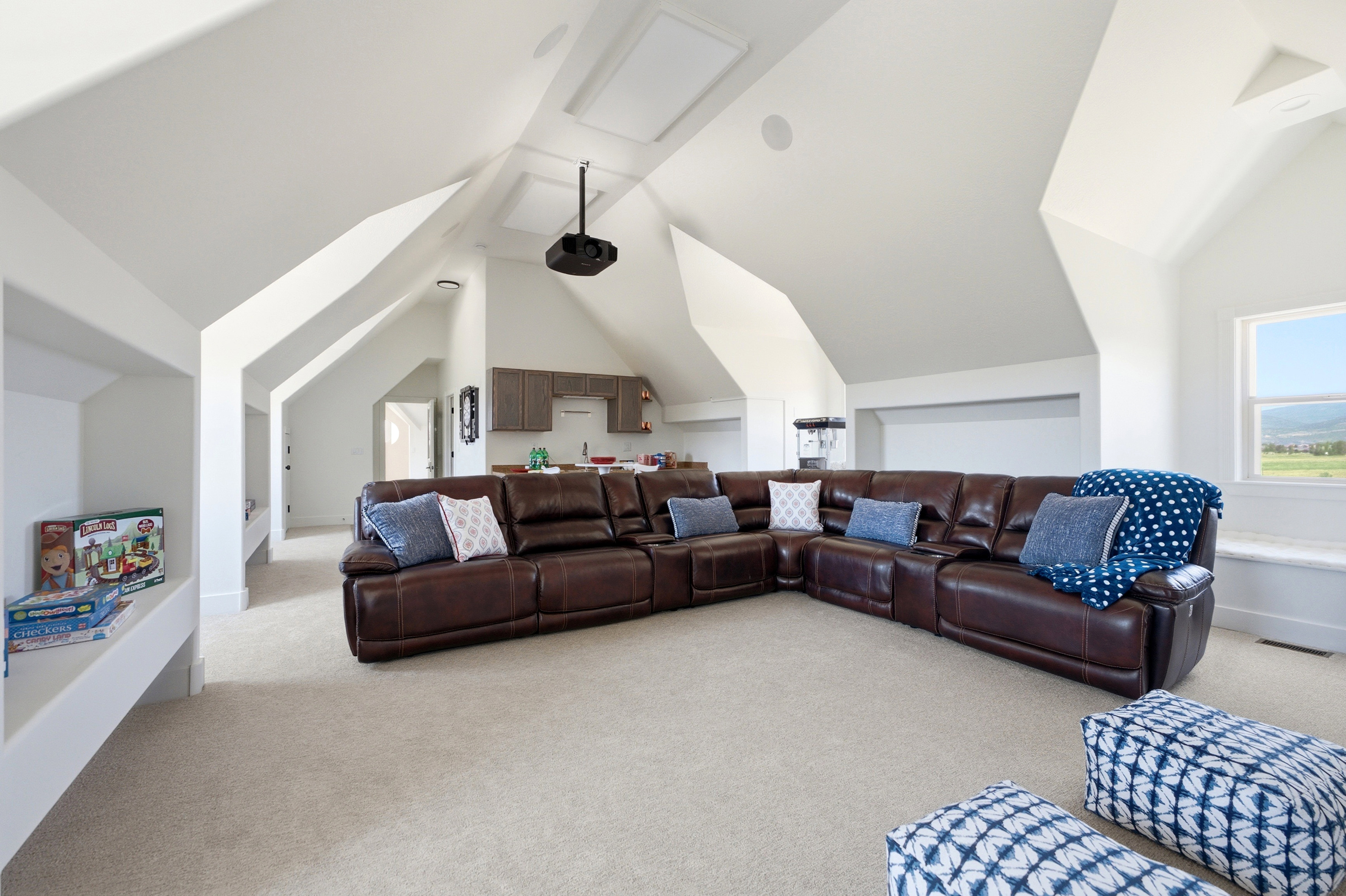 Spacious bonus room featuring vaulted ceilings, recessed lighting, wall-to-wall carpeting, a built-in wet bar with cabinetry, and a ceiling-mounted projector