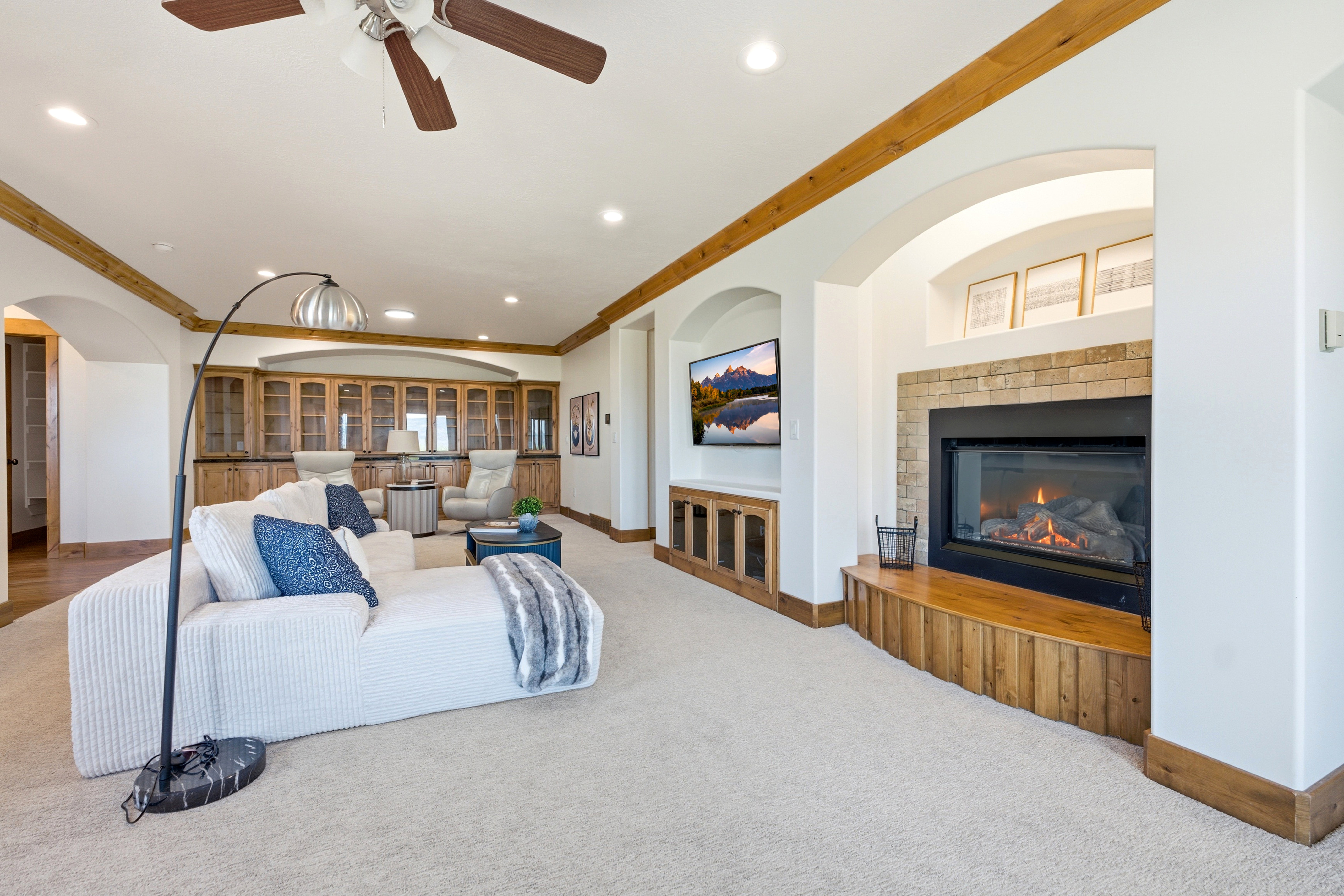 Living area featuring a stone-surround fireplace with a wood hearth, recessed lighting, and a ceiling fan
