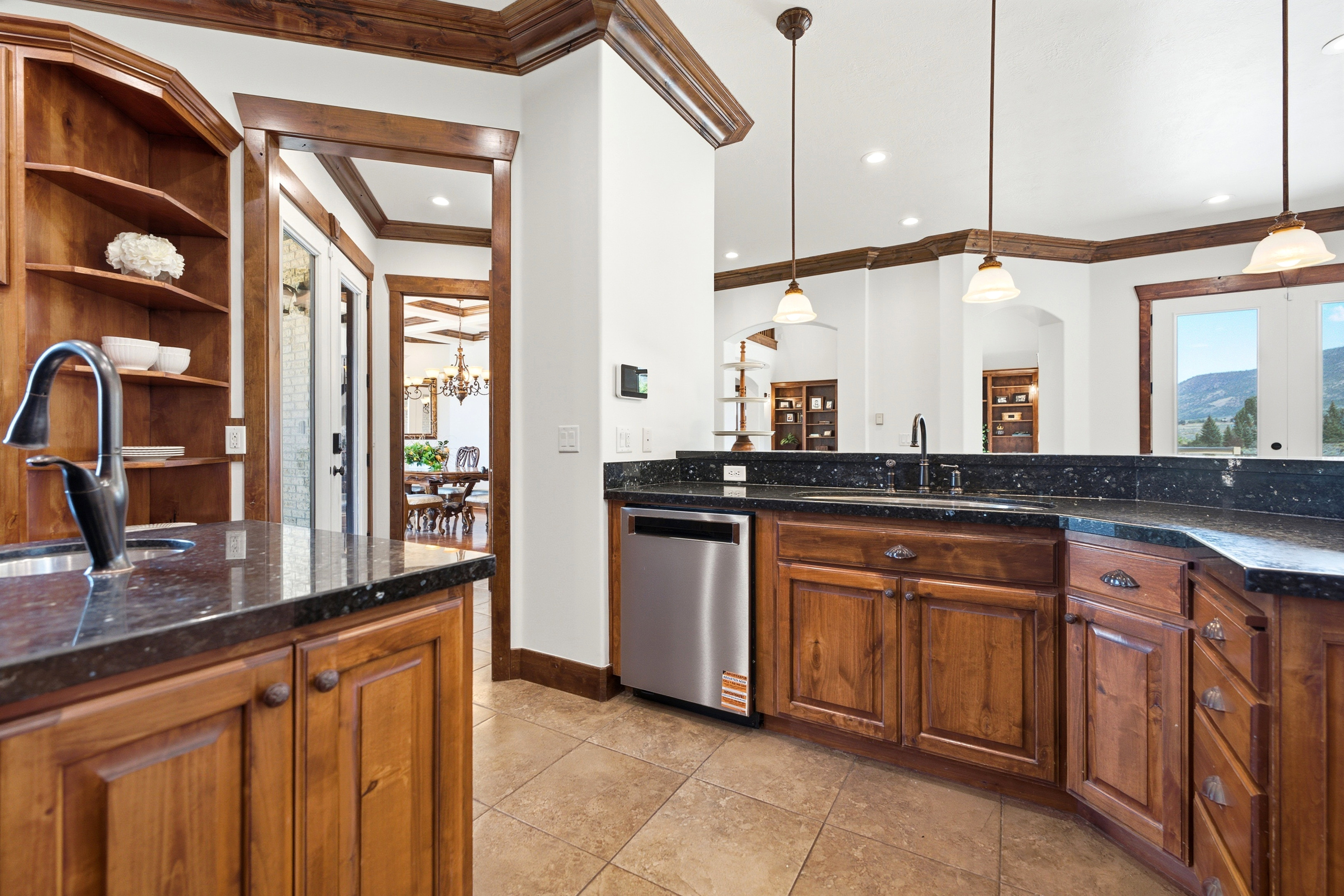 Kitchen featuring dark granite countertops, warm wood cabinetry, and stainless steel appliances