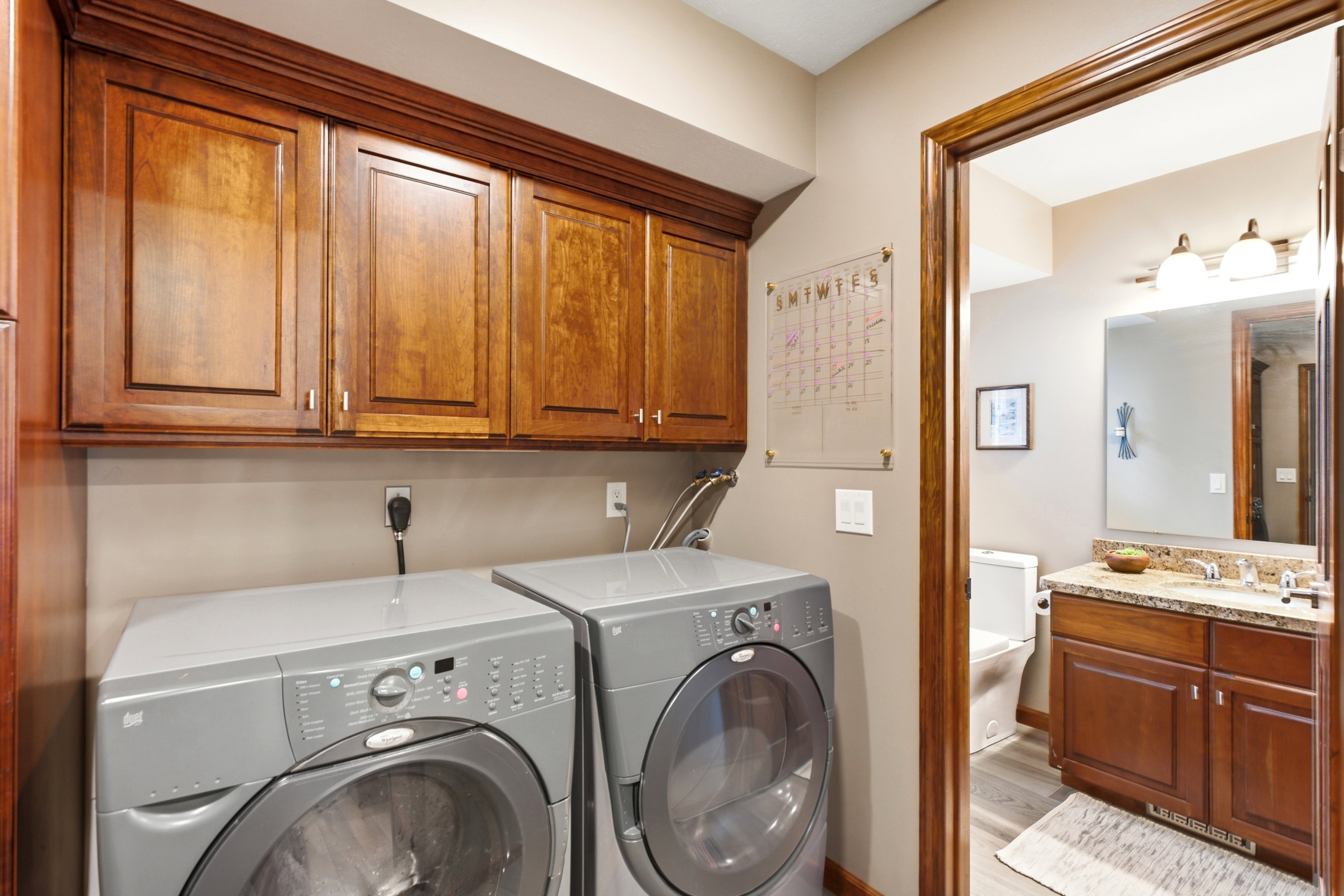 Laundry area featuring rich wood cabinetry with crown molding