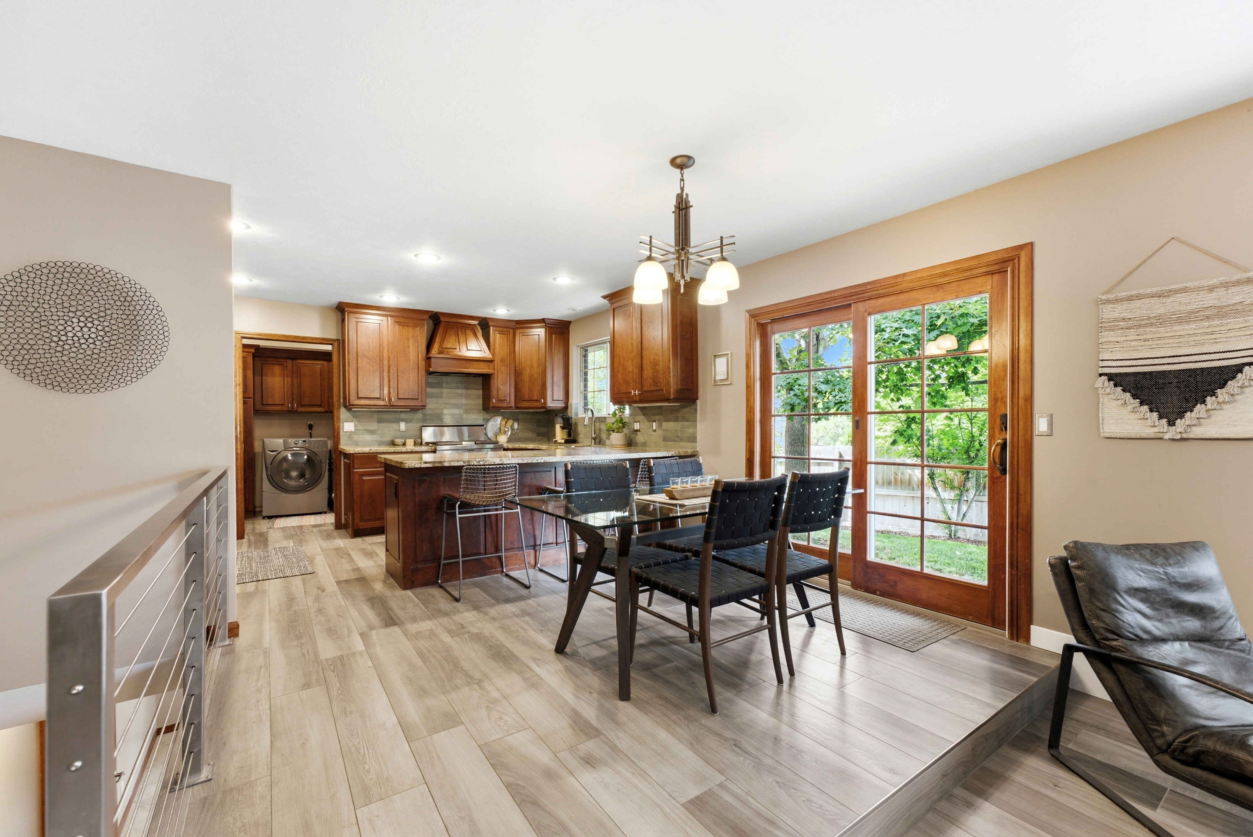 Open-concept kitchen and dining area featuring wood-finish flooring, recessed lighting, and a sliding glass door to the exterior.
