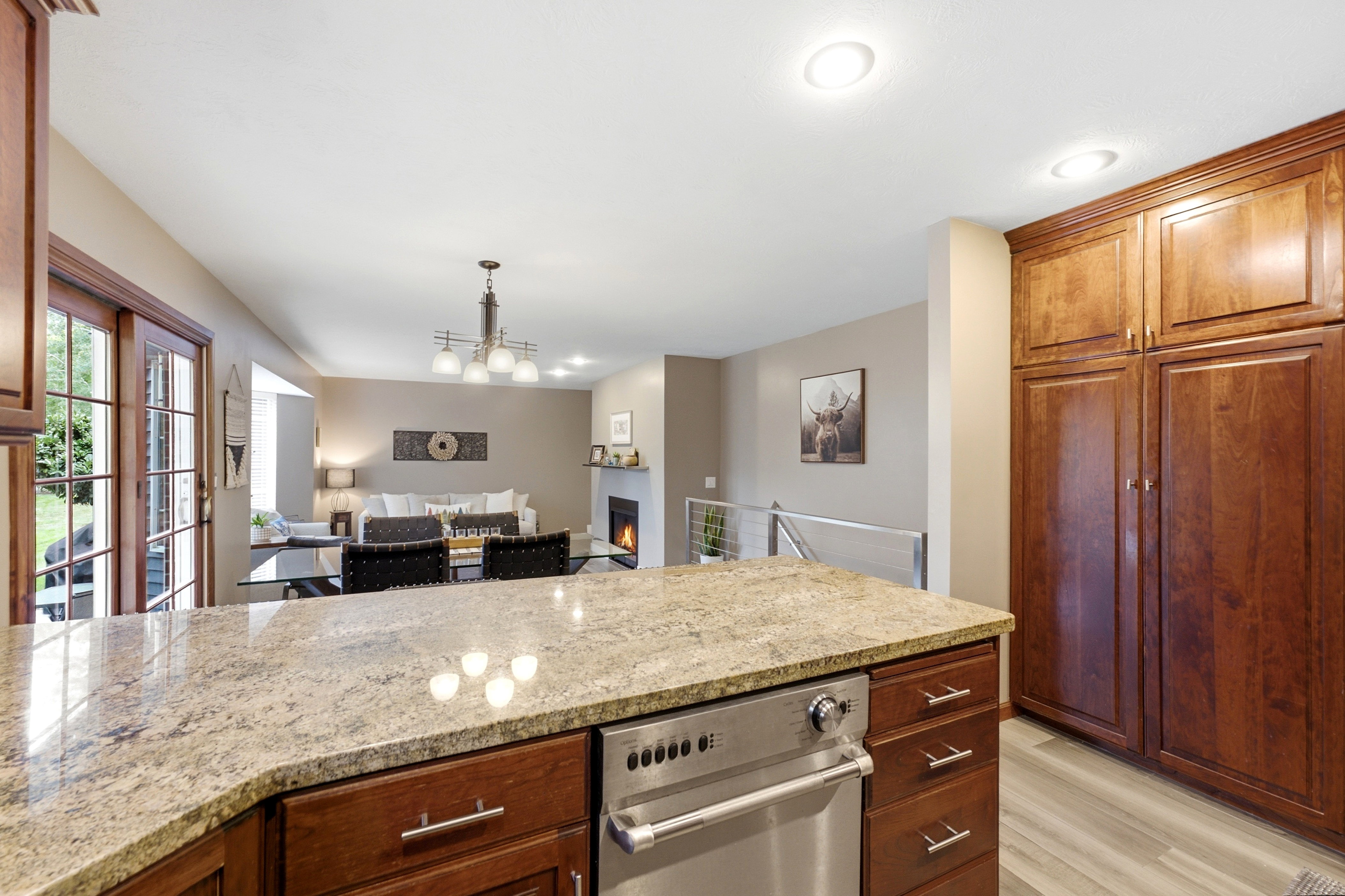 Kitchen island with a light-toned granite countertop and an integrated stainless steel dishwasher.