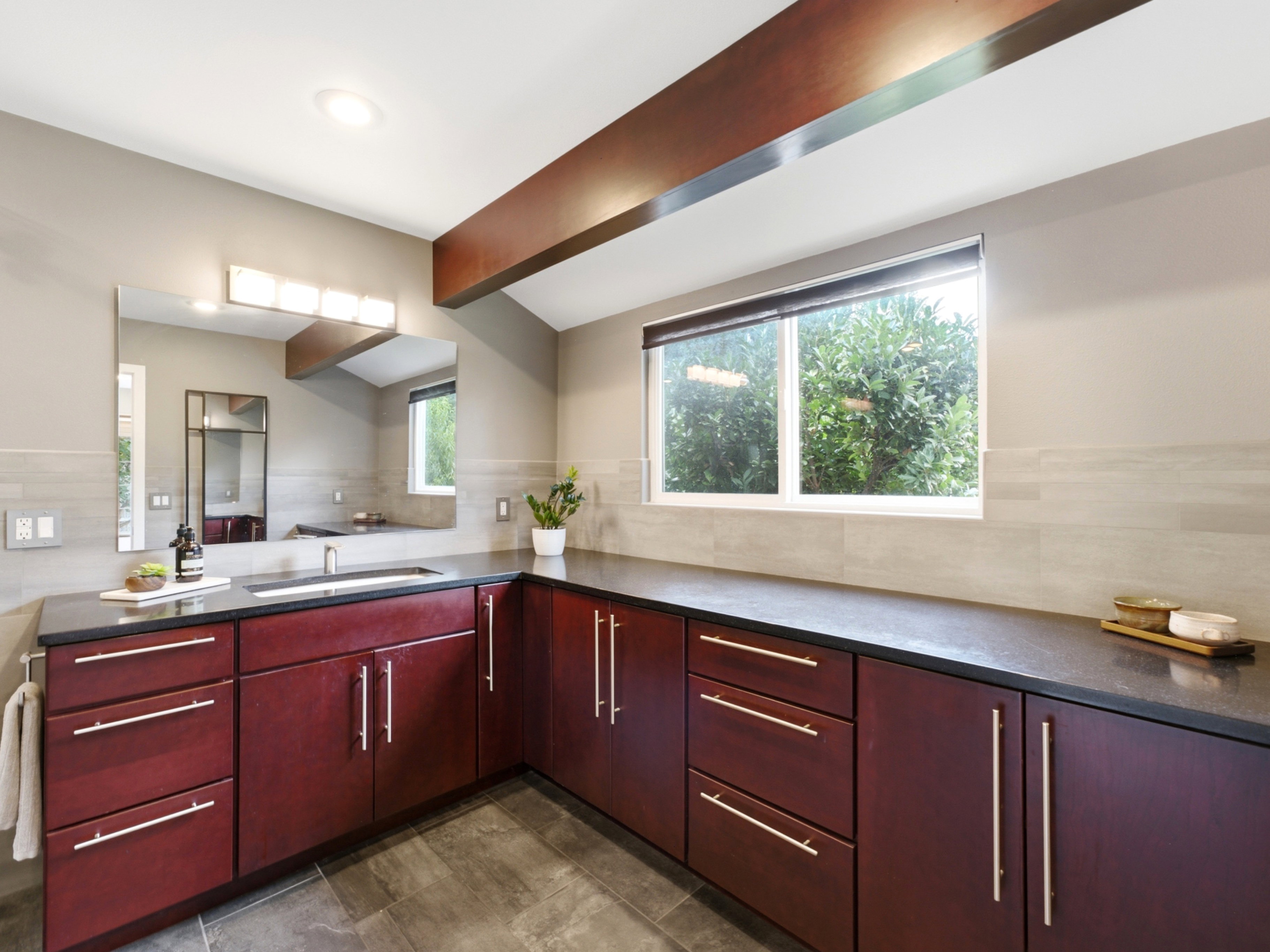 Expansive vanity featuring dark wood cabinetry, a dark countertop.