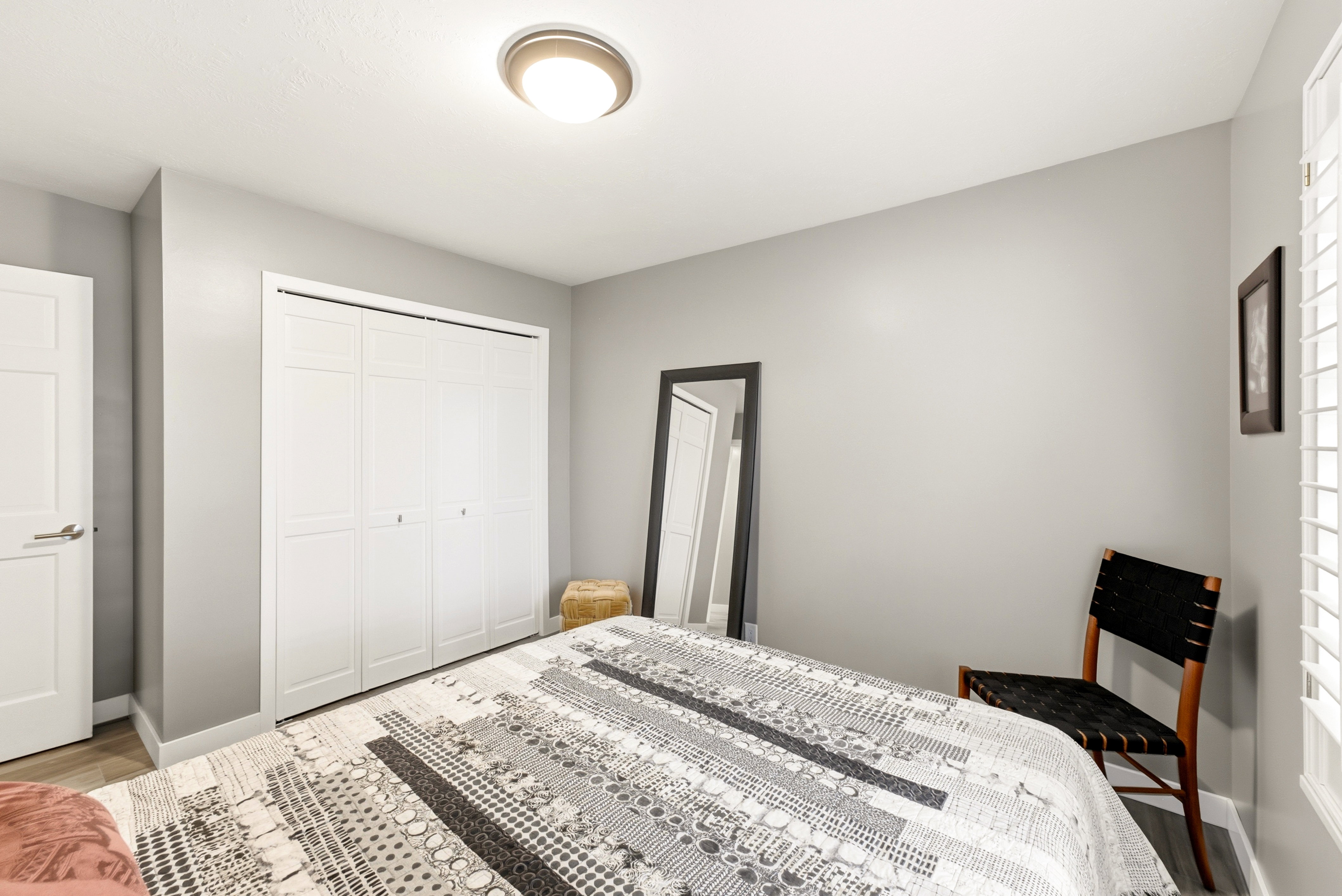Room featuring light gray walls, wood-finish flooring,  and white door trim.
