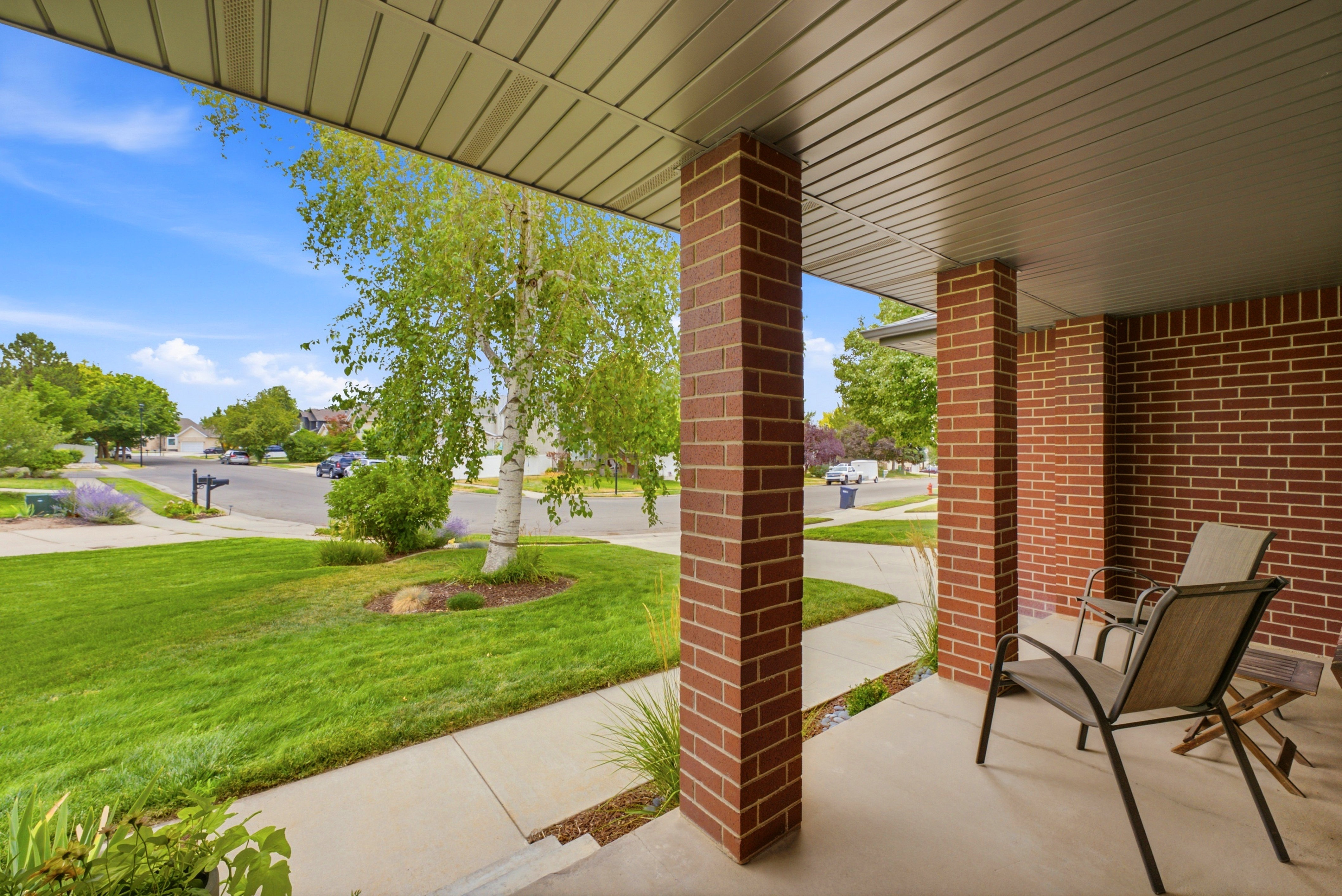 Covered front porch featuring brick columns and a brick exterior wall