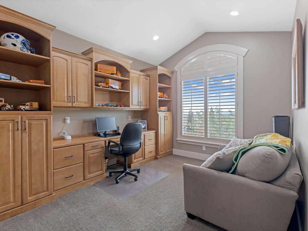 Built-in wood cabinetry and desk featuring extensive storage and display shelving