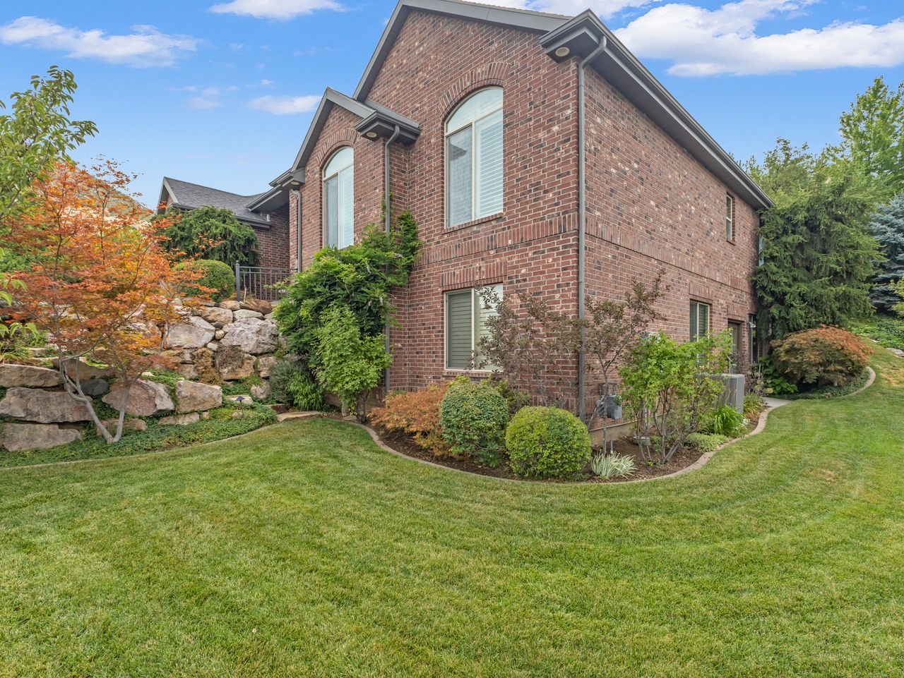 Brick exterior featuring arched windows, dark gray gutters, and a pitched roofline