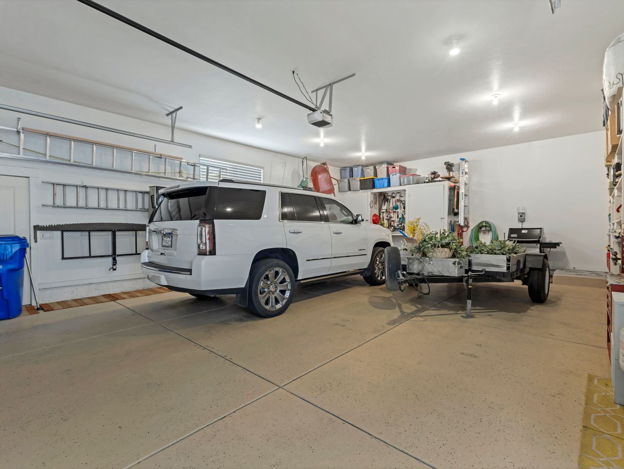 Spacious garage featuring a light-toned concrete floor, white walls, and recessed lighting