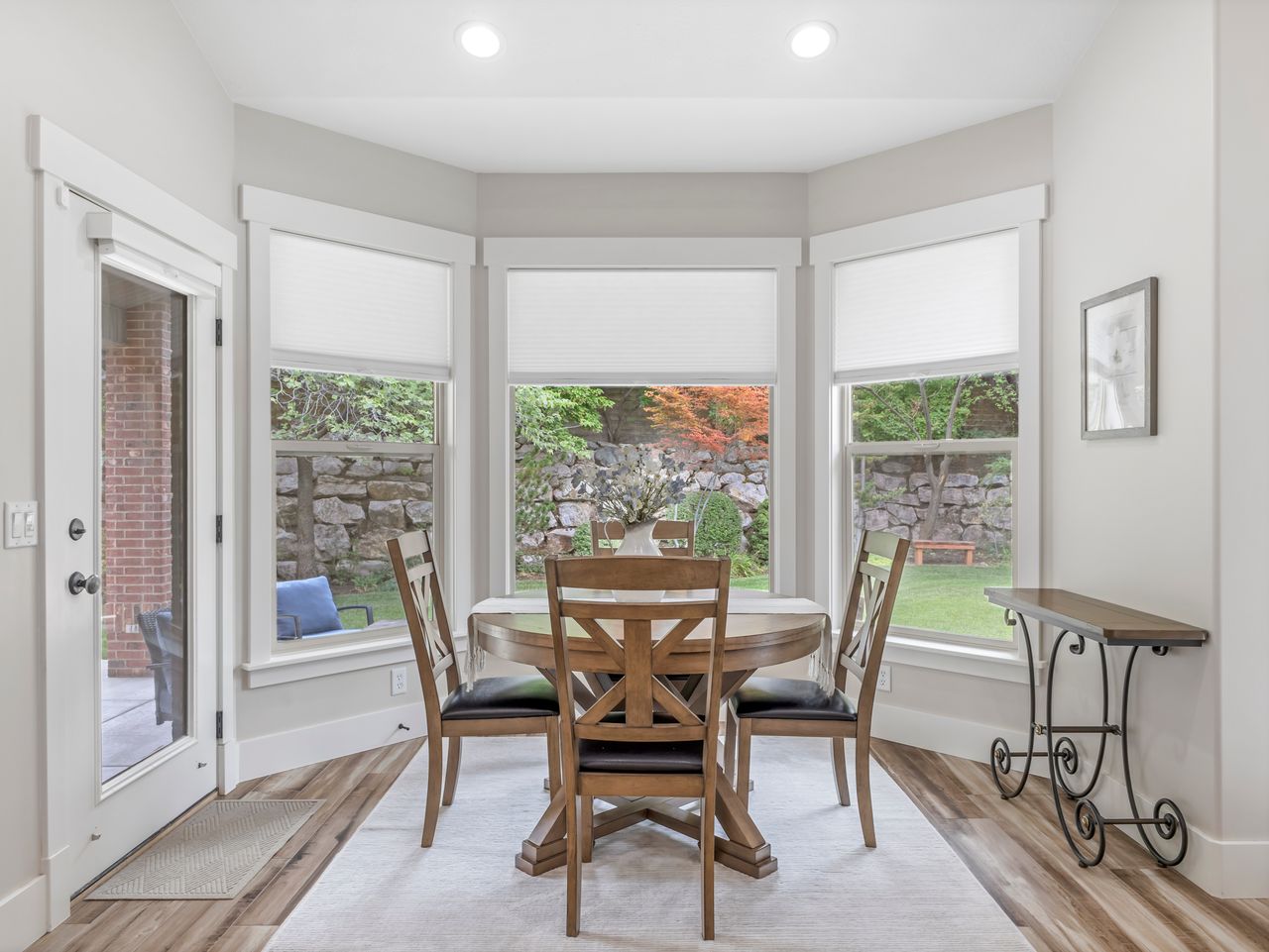 Bay window dining space with wood-finish flooring, recessed lighting, and a glass-paneled exterior door