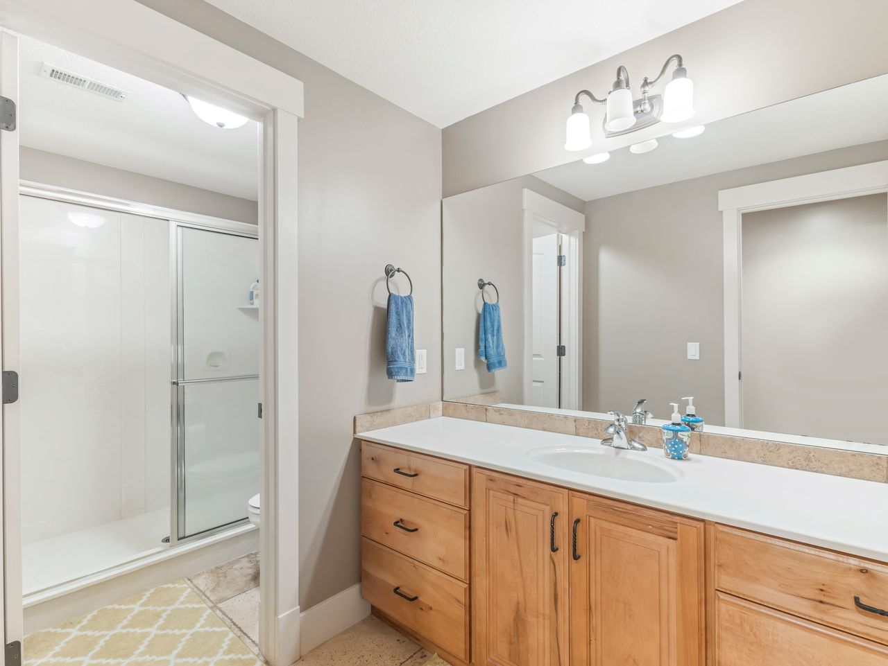 Bathroom featuring an extended wood-finish vanity with ample storage
