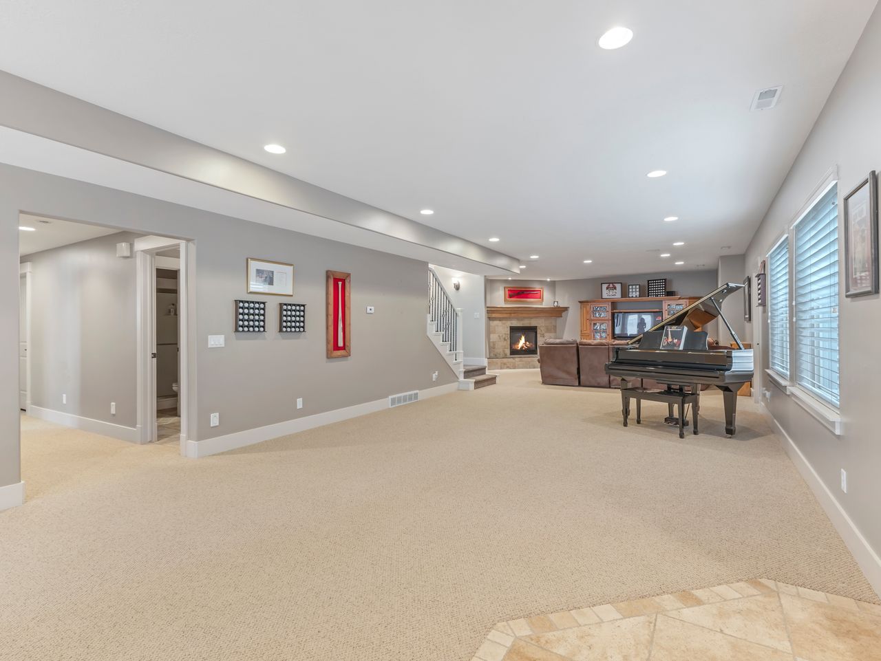 Spacious interior room featuring light-toned carpeting and recessed lighting