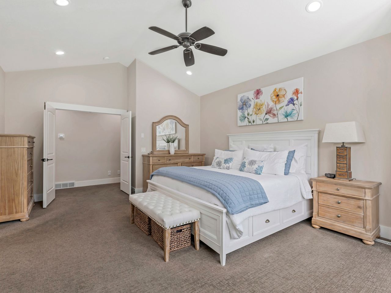 Spacious bedroom featuring a vaulted ceiling with a ceiling fan, recessed lighting, carpet flooring, and double closet doors