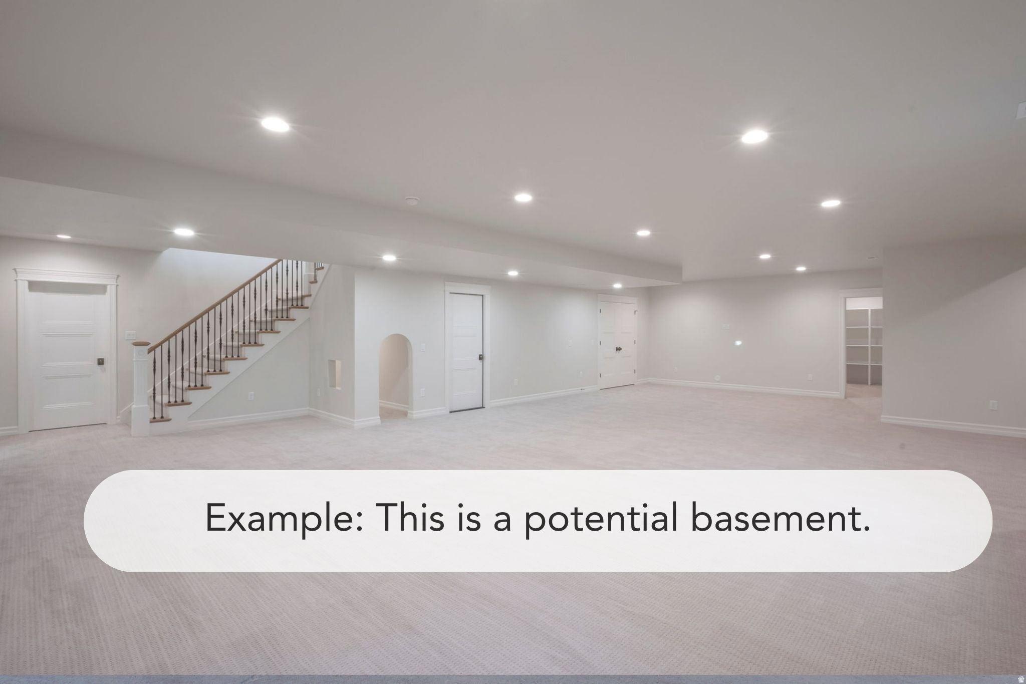 Spacious room featuring light-colored carpeting, multiple recessed ceiling lights, and a staircase with wood-finish handrails and white balusters