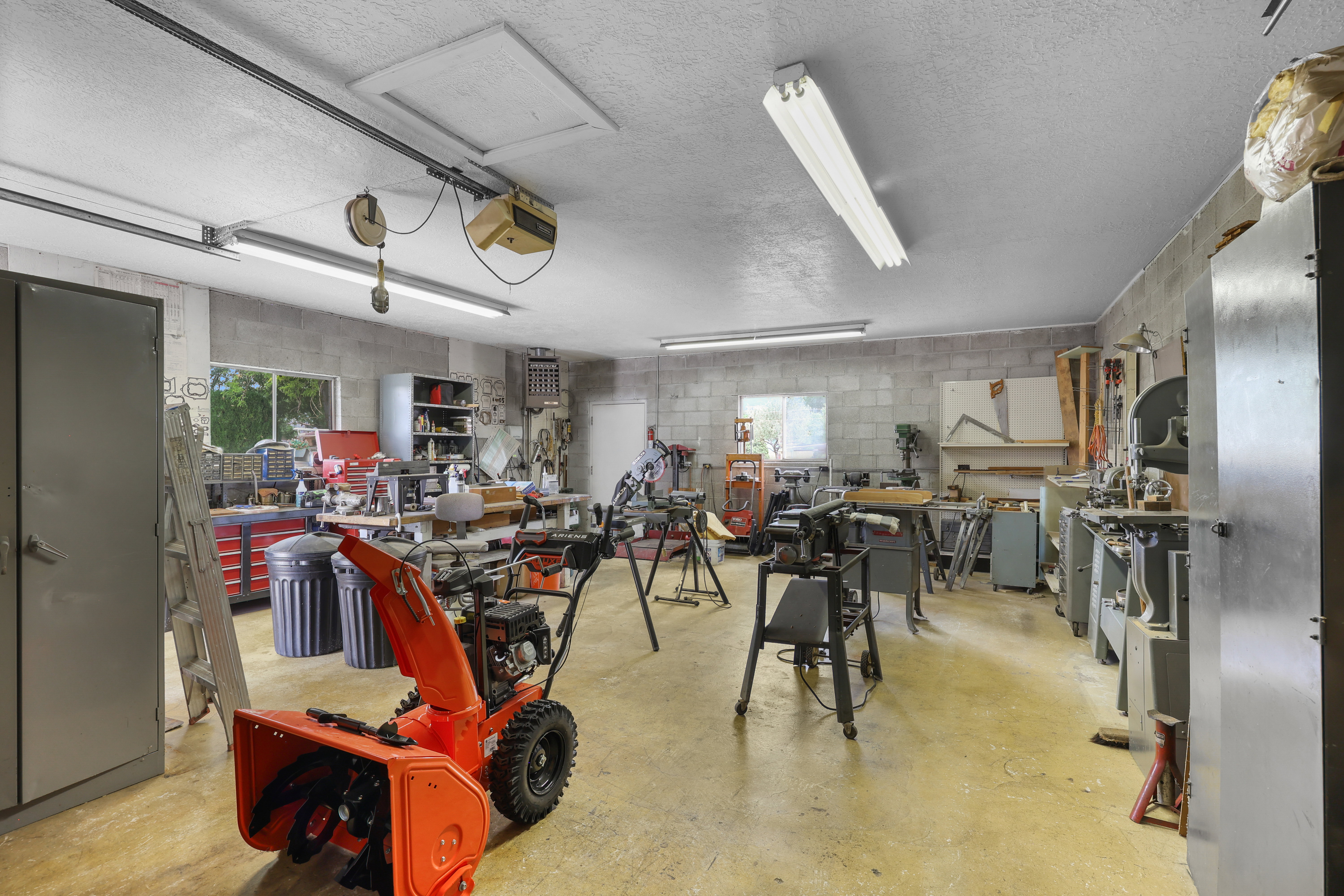 Spacious workshop area featuring concrete block walls and a concrete floor