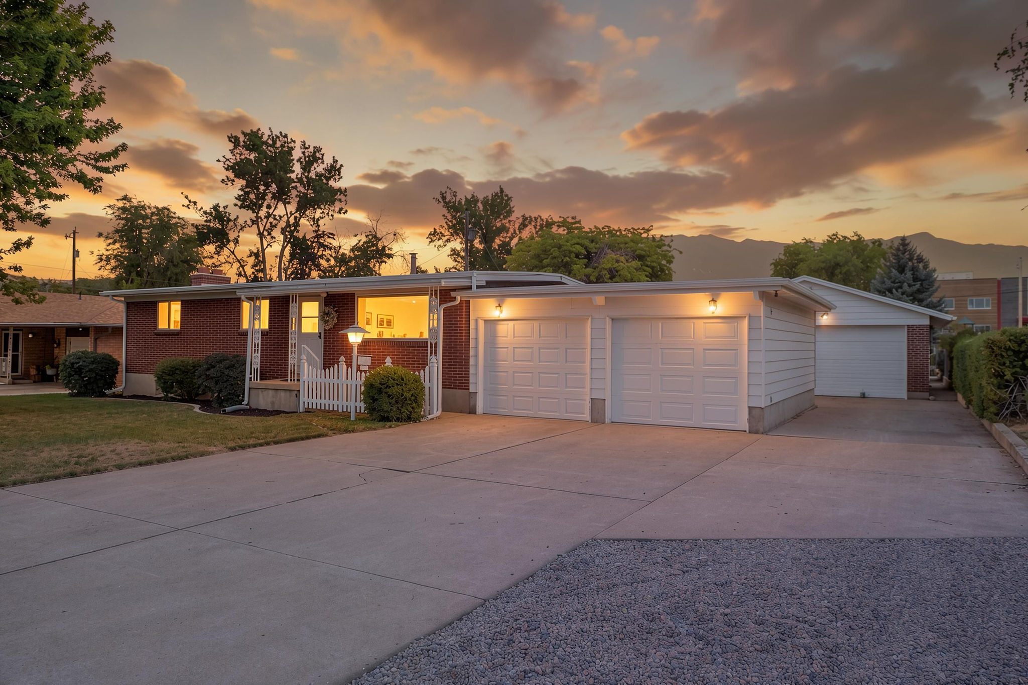 Brick exterior with white trim, featuring a double garage and an additional single garage