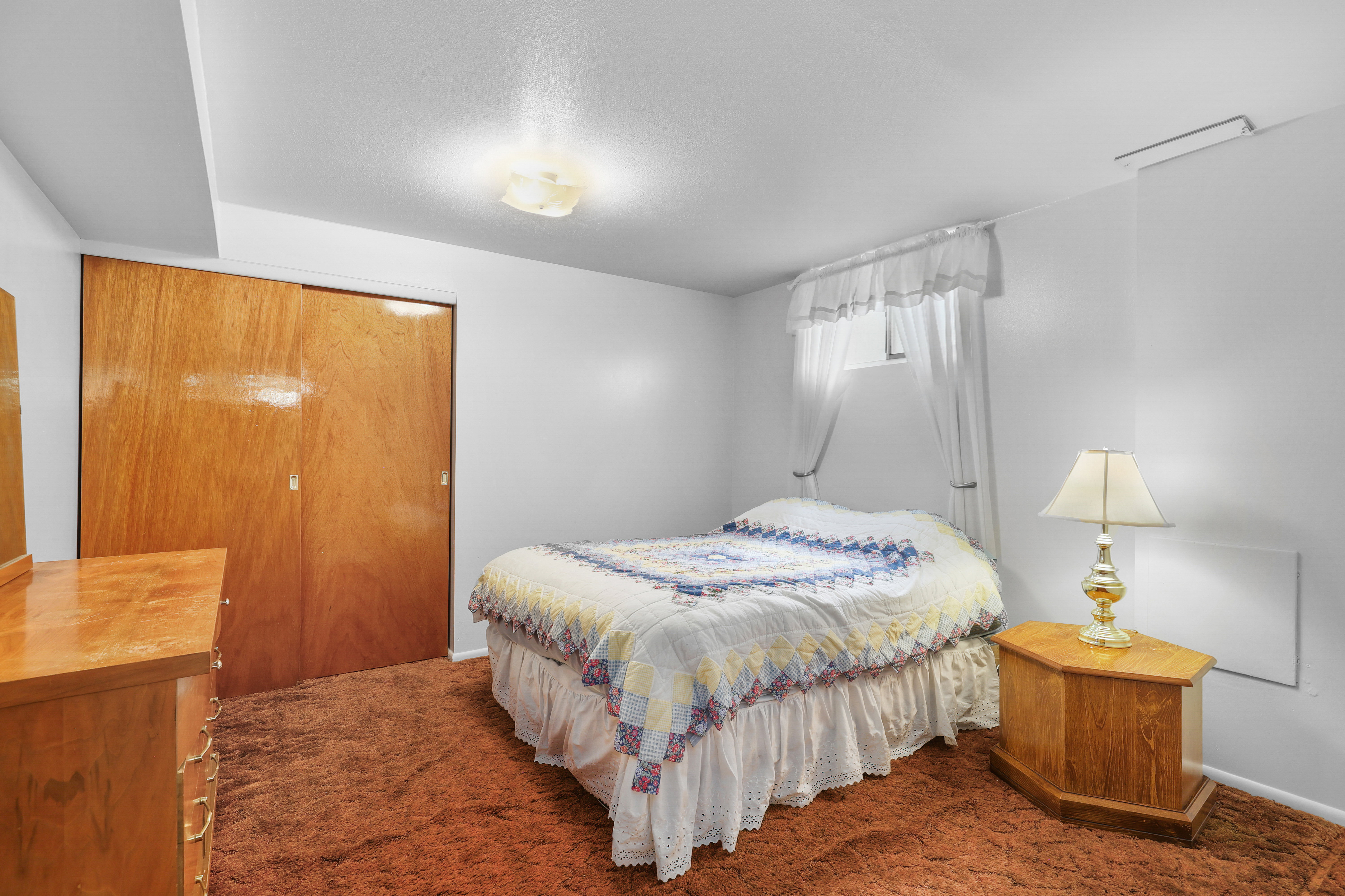 Bedroom featuring rich brown carpeting and white walls