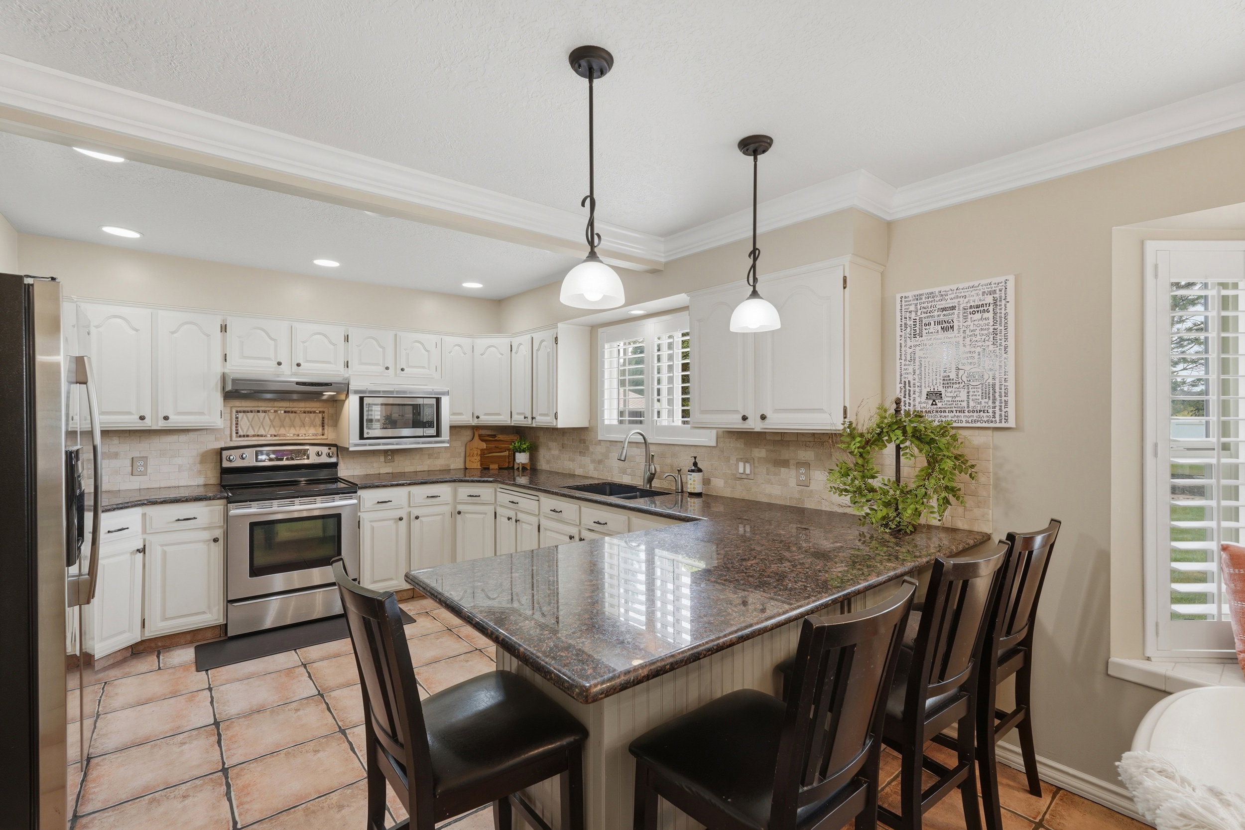 Kitchen featuring white cabinetry, stone-finish countertops, and tile flooring